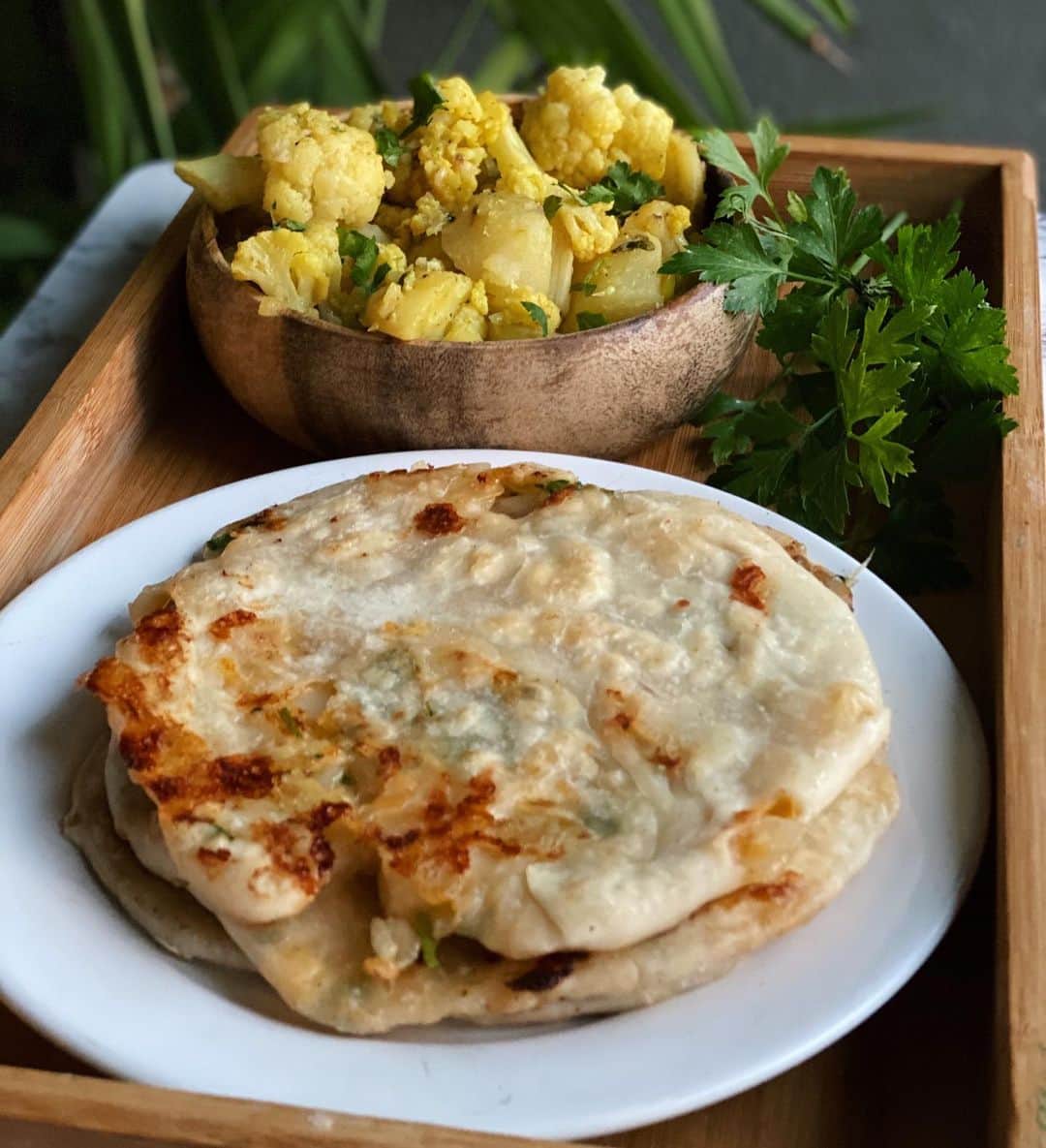 Antonietteのインスタグラム：「Aloo-ve Indian food! Aloo gobi (spiced cauliflower and potatoes) accompanied with cheese, onion and chili parathas. So good! Trust me, you’ll  want to make the parathas, and you can omit the cheese if you want to make it vegan. Perfect for #meatlessmonday ! . . . . Cheese, onion and chili paratha   Dough : * 1.5 cups flour * 1/4 teaspoon salt * 1 teaspoon oil  Filling: * 1 small onion, finely chopped * 1 jalapeño or other green chili chopped * Cup of cilantro chopped * 1/2 cup of the following cheeses: mozzarella, cheddar, paneer but can use what you have available.  * 1/2 teaspoon chili powder * Pinch of salt * 4 teaspoons melted butter, ghee or oil   Make dough by combining flour, salt, and oil and slowly add 1/3 cup water to make a soft dough. Add a little more to make it pliable. Knead for about a minute or two and then  have the dough rest for ~30 mins.   Combine all ingredients for filling and set aside.  Once dough is rested, divide equally into 4 portions, and roll into a 3-4 inch circle. Add some filling, pinch to seal and roll it out into a larger circle, about 6-7 inches.   Repeat the process for all the other dough portions.   Cook paratha in a heated skillet brushed on with a bit of butter, ghee or oil  until golden and crispy. Eat it of course! 😆」