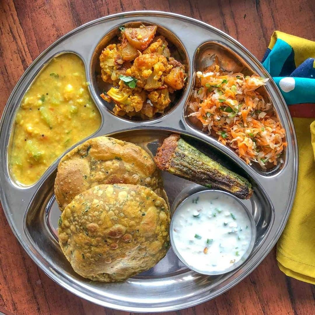 Archana's Kitchenのインスタグラム：「Here's a delicious and wholesome Portion Control Meal Plate which includes Turai Moong Dal, Aloo Gobi Ki Sabzi, Bharwa Karela with Sweet Potato Filling, Bitter Gourd Peel Puri, Carrot, Radish & Peanut Salad with Lemon and Spring Onion and Peanut Raita.   #archanasportioncontrolmealplates」