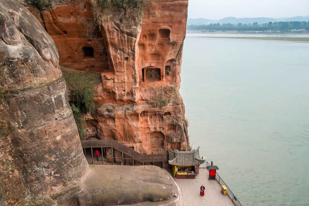 National Geographic Travelさんのインスタグラム写真 - (National Geographic TravelInstagram)「Photos by @francescolastrucci / This is the Leshan Giant Buddha Scenic Area in the province of Sichuan, China. The area is most famous for the 71-meter-high (233-foot-high) Giant Buddha. It was carved in the eighth century on a cliff by the confluence of three rivers. The vast area of natural beauty is dotted by temples, bridges, pagodas, and stone carvings. I enjoyed focusing on the daily life that surrounded the Giant Buddha. (1) A fisherman drags his net along one of the river branches. (2) The view from a window of one of the many temples. (3) A monk stands at the feet of the Giant Buddha.  Follow me @francescolastrucci for more places, daily life, and stories around the world. #china #giantbuddha #history #dailylife」2月24日 1時02分 - natgeotravel