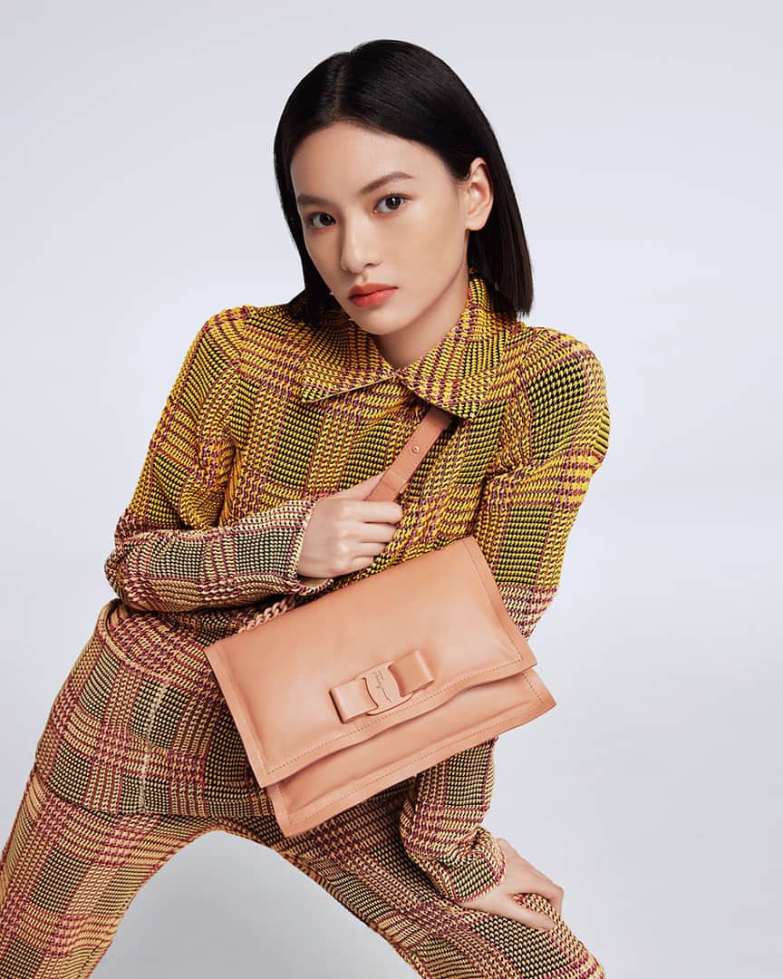 サルヴァトーレ・フェラガモのインスタグラム：「Qiu Tian is insouciantly cool dressed in a checked seersucker suit paired with a supple and exquisite blush Viva Bow bag that is slightly padded and soft to the touch, with the distinct bow in a tonal finish. #VivaBowBag」