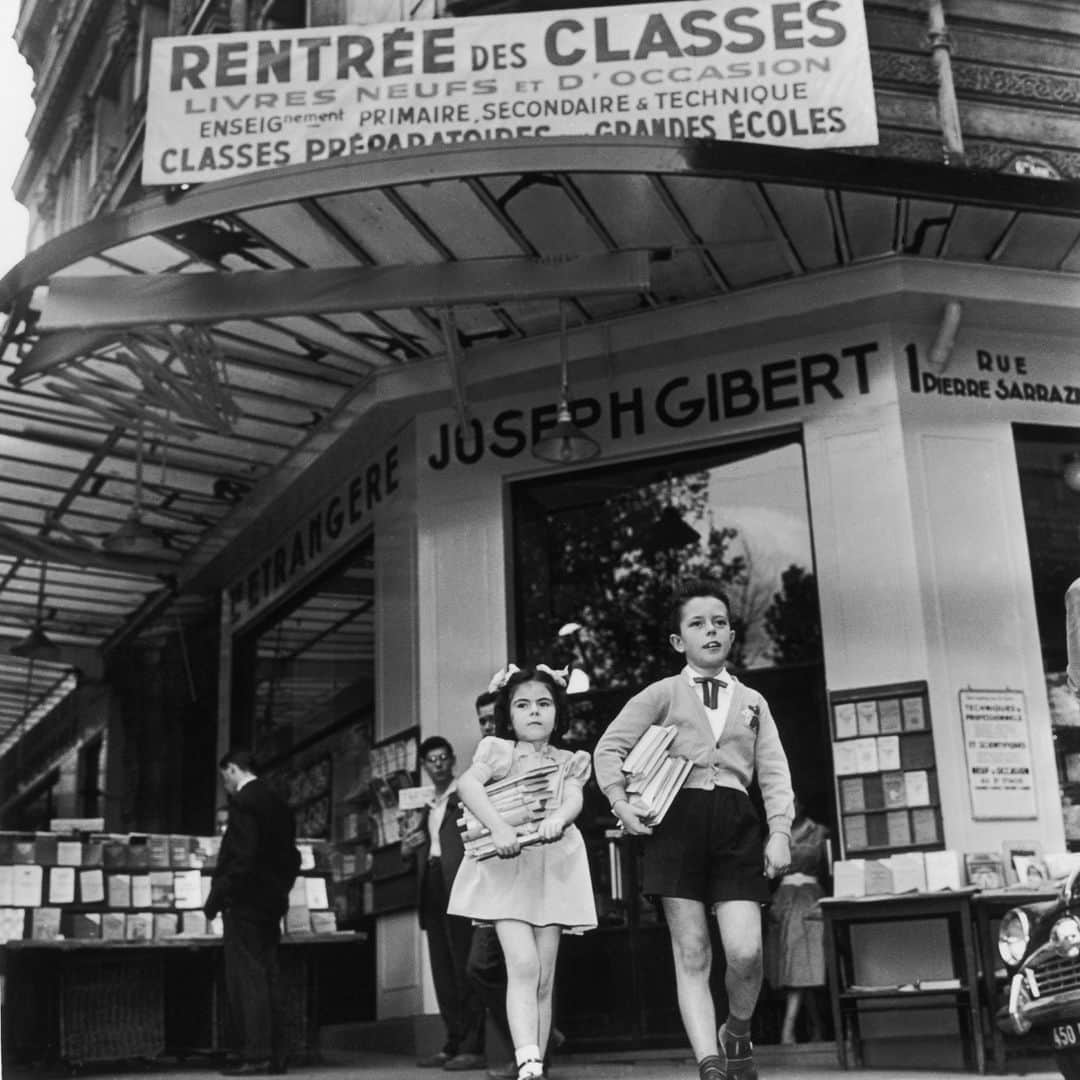 ルモンドのインスタグラム：「Quand la grande librairie Gibert Jeune, à Paris, baissera définitivement ses stores à la fin du mois de mars, que les étals et rayonnages auront été débarrassés de la multitude de livres neufs ou d’occasion qui fit sa réputation et sa gloire, que les vieux escalators récemment rénovés s’immobiliseront, plongeant l’immeuble principal dans un étrange silence uniquement rompu par le glissement furtif des souris, et qu’enfin libraires, vendeurs, vigiles, caissières et manutentionnaires franchiront une dernière fois les portes des quatre sites donnant sur la place Saint-Michel, où beaucoup ont fait la quasi-totalité de leur carrière, alors c’est une longue page d’histoire qui se tournera tristement.⁣ L’histoire d’un quartier de Paris autrefois si joyeux et longtemps associé à l’étude, aux idées, à la jeunesse et à la connaissance ; l’histoire de la librairie française, confrontée à de nouvelles habitudes de lecture et d’achat et à un marché de l’immobilier asphyxiant ; l’histoire aussi d’une dynastie – les Gibert – qui, en cent trente-cinq ans, a porté au plus haut l’étendard de la librairie indépendante et entretenu avec des générations d’étudiants, bibliophiles et lecteurs, un lien d’extrême familiarité au point que beaucoup le croyaient éternel.⁣ Pourtant, les deux dirigeants actuels de Gibert Joseph s’insurgent contre le message négatif perçu de toutes parts. « L’aventure Gibert continue !, affirment-ils. La famille Gibert reste à la barre et n’a pas l’intention de baisser pavillon. Nous continuons de croire au livre et à la démocratisation du savoir. Comme Joseph le patriarche, débarqué à Paris il y a cent trente-cinq ans. » Et d’insister : la librairie du 26, boulevard Saint-Michel, demeure, avec ses 4 200 mètres carrés de surface, ses 400 000 références et ses quinze millions de volumes vendus par an, la première librairie indépendante de France.⁣ -⁣ Le 20 septembre 1958, deux écoliers, les bras chargés de livres, sortent de la librairie Gibert Joseph à Paris. Photo : Keystone-France (@gammarapho)⁣ -⁣ #culture #economie #quartierlatin」