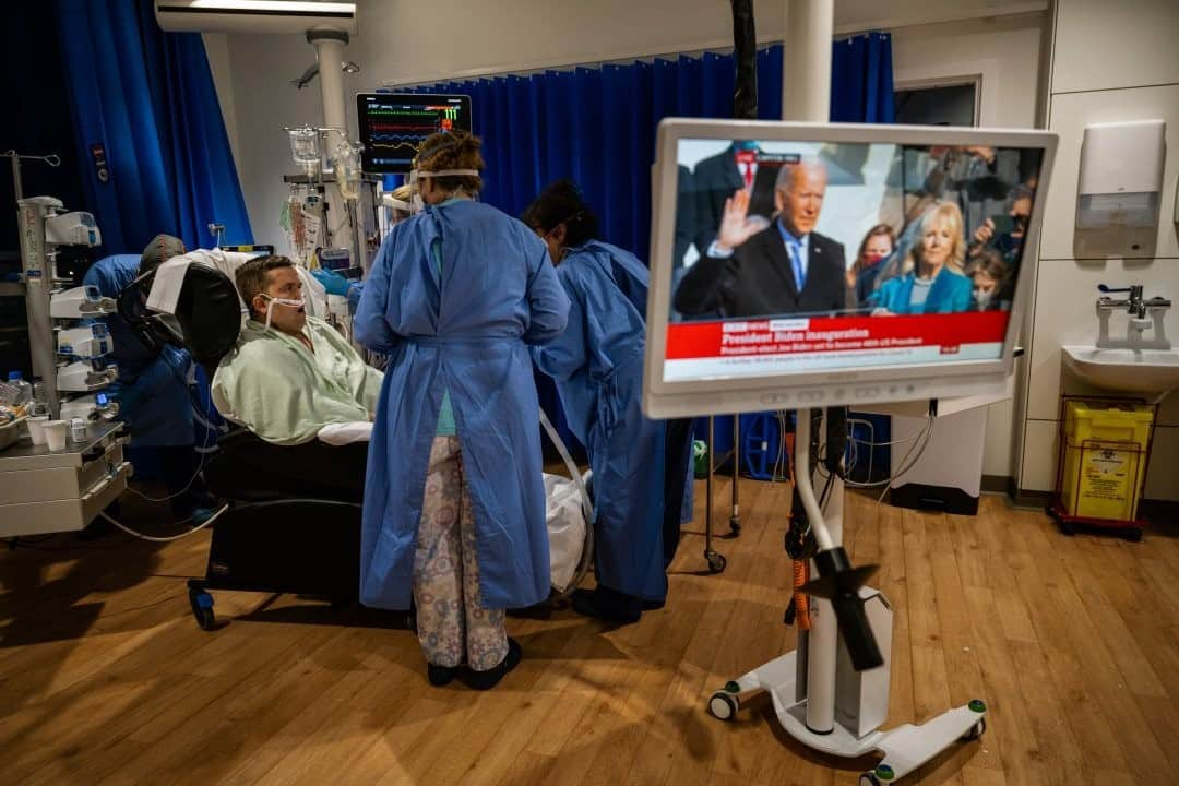 ナショナルジオグラフィックさんのインスタグラム写真 - (ナショナルジオグラフィックInstagram)「Photo by @lynseyaddario / Joe Biden is sworn in as president of the United States as COVID-19 patient Cornel Iordache, 36, is prepared to move to another bed in the critical care unit of Royal Papworth Hospital in Cambridge, England, on January 20, 2021. Iordache, a weightlifter, had a breathing tube removed earlier that morning and was making extraordinary progress. Medical staff at Royal Papworth are tending to COVID-19 patients in four areas which have been reallocated to deal with a surge in COVID patients: two critical-care provision areas and two noncritical-care areas. RP is the specialist heart and lung hospital for the east of England and parts of north and east London, and it is one of five hospitals in England with ECMO (extracorporeal membrane oxygenation) service for patients in acute severe respiratory failure. The ECMO machine pumps and oxygenates a patient's blood outside the body, which essentially does the job of the lungs externally in order to give the body a chance to rest and recover.」2月25日 2時33分 - natgeo