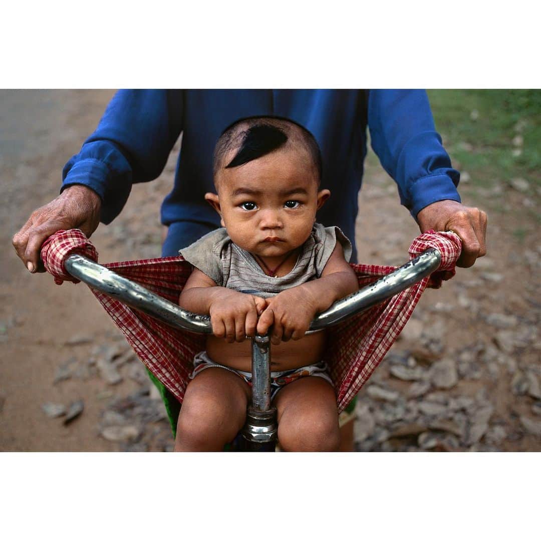 スティーブ・マカリーのインスタグラム：「Boy in a makeshift bicycle sling and his mother on their way home. Banteay Srei, Angkor Wat, #Cambodia, 2000.  #SteveMcCurry」
