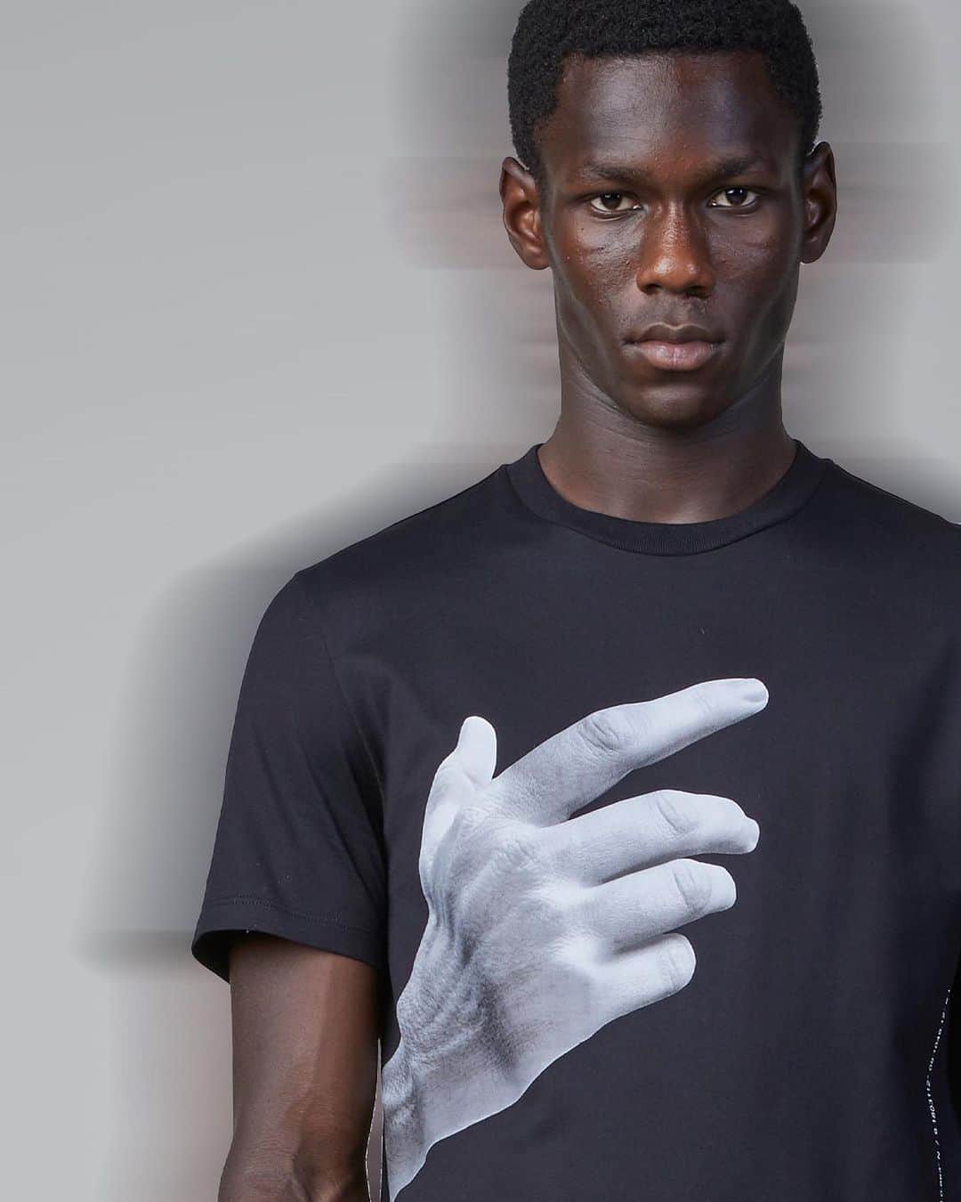 のインスタグラム：「Hands represent gestures of Creativity and Craft. Unique to each person, they express our Soul.  DNA / A UNIFORM FOR THE EVERYDAY  The new NEIL BARRETT SS21 COLLECTION expresses the essence and meaning of the BRAND’S DNA.  @ _cheikhdia in Neil Barrett “The Other Hand Series / 01” T-Shirt.  Discover the New Collection at NeilBarrett.com  #NeilBarrett #SS21 #NewCollection #DNA」