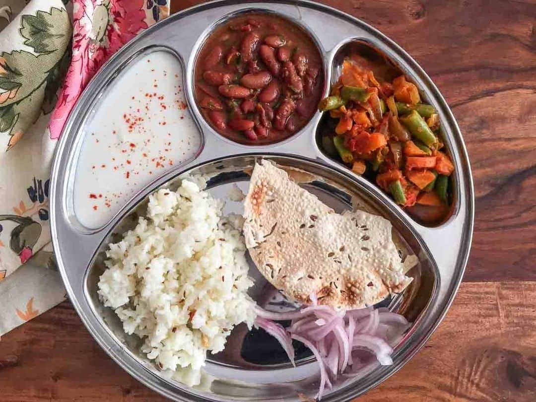 Archana's Kitchenのインスタグラム：「In today's meal plate we have an all time favorite rajma masala, that is made with no onion and no garlic option. Then we have a simple sabzi made from carrot and beans that is tossed with some onions and tomatoes. A plain curd will help you satisfy your palate. The curries can be had with some jeera rice. Pickles onions and crispy papad for a good crunch.   #archanasportioncontrolmealplates」