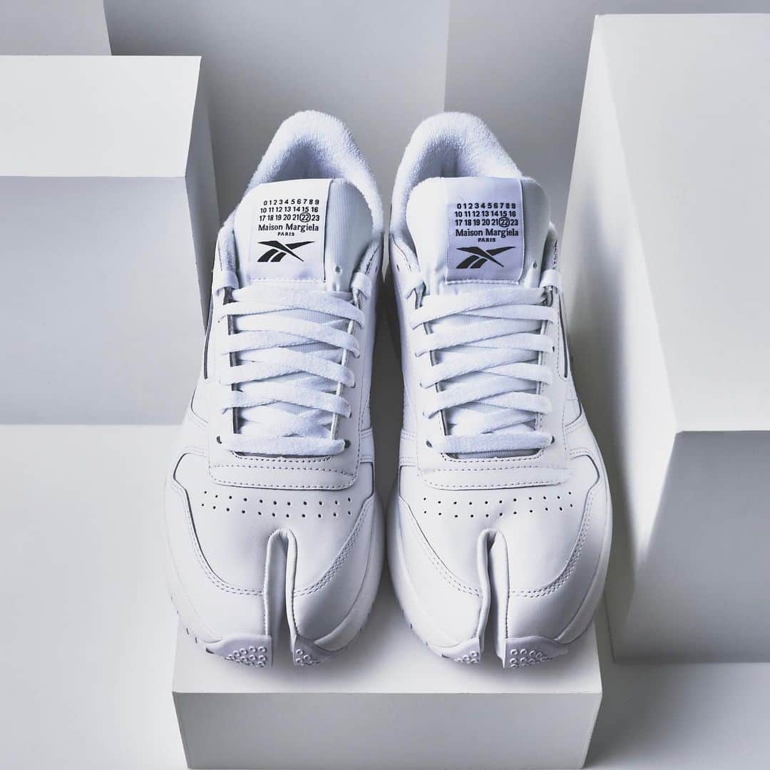 LOVELESS/GUILD PRIME 公式アカウントのインスタグラム：「「INFO」 Maison Margiela×Reebok wil be available from 26th Feb at LOVELESS AOYAMA.  Maison Margielaのアイコンシューズである「Tabi」とReebokの「Classic Leather」を融合した「Classic Leather Tabi」をラブレス青山にて明日2/26(金)に発売いたします。 ﻿ リーボックの定番モデル「クラシックレザー（Classic Leather）」をベースに、つま先にメゾン マルジェラの「タビ」のフォルムを取り入れたデザイン。また、製品には「Tabi」型のオリジナルコラボレーションソックスも付属しております。  Classic Leather Tabi  WHITE 38.5/41.0/42.0/43.0/44.0 BLACK 37.5/38.5/41.0/42.0/43.0/44.0 ¥35,200  [販売店舗] ラブレス青山 @loveless_aoyama   ‐ ご来店 / 販売に関する注意点 ‐ ※前日から路上等には並ぶことはご遠慮ください。 ※販売当日、混雑した場合には整理券を配布いたします。 ※整理券をお持ちでも、在庫がなくなり次第終了となり、ご購入いただけない場合がある旨をご了承ください。 ※表参道駅側入口から店の外壁に沿って10:30より店外にお並び頂けます。 ※1会計につき1足までとさせていただきます。 ※商品のお取り置き対応は致しません。また、お電話での代引き配送の受付は2月26日の13:00以降より承ります。  クリエイティブディレクターのジョン・ガリアーノは、今日の意識の高いエシカルな考え方とサイエンスを反映し、 アメリカのスポーツウェアスタジオのクラシックスニーカーと、フランスのオートクチュールアトリエのタイムレスなアイコンシューズを融合させました。  @maisonmargiela @reebok  #loveless #lovelessaoyama #loveless_select  #margielatabi #reebok #margielareebok #maisonmargielaxreebok  #maisonmargiela #margiela  #johngalliano #johngalliano  #women #men #unisex  #21ss #fashion #マルジェラ #メゾンマルジェラ #マルジェラリーボック  #メゾンマルジェラリーボック  #ラブレス #ラブレスセレクト #ラブレス青山」