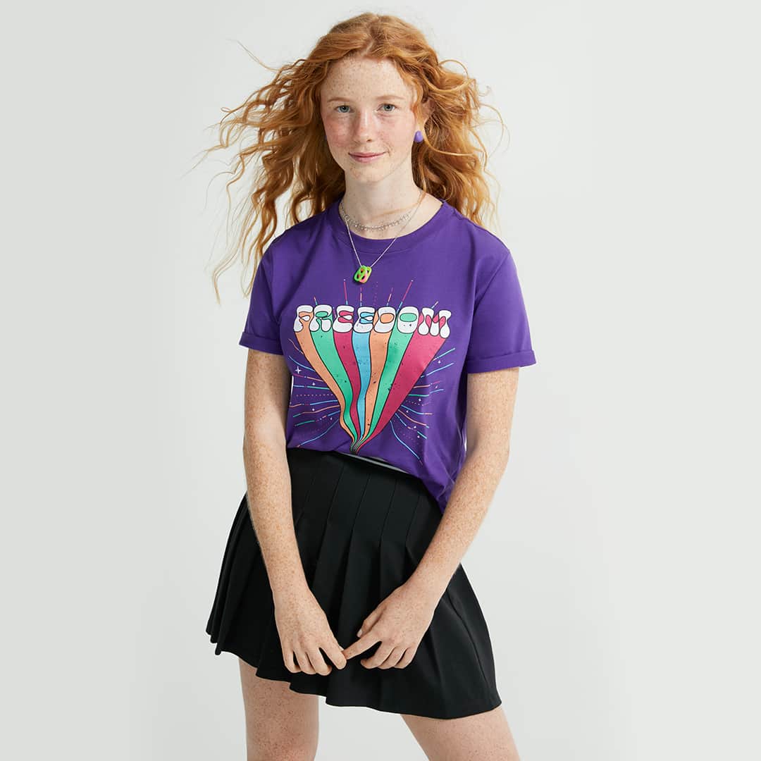 のインスタグラム：「Toda a beleza e a liberdade de experimentar o seu estilo como e quando você quiser! Aproveite as novidades no site ou app e se jogue nas tendências da coleção #teens, feita especialmente em tamanhos menores. ❤️ . . . #PraCegoVer #PraTodoMundoVer: o post é um carrossel com duas imagens de uma modelo com o mesmo look em ângulos diferentes, dispostas sobre um fundo claro. Na primeira, posa com os cabelos ao vento. Na segunda, sorri com a câmera mais próxima. Ela veste blusa roxa com estampa colorida escrito "Freedom", saia preta plissada e acessórios coloridos.」