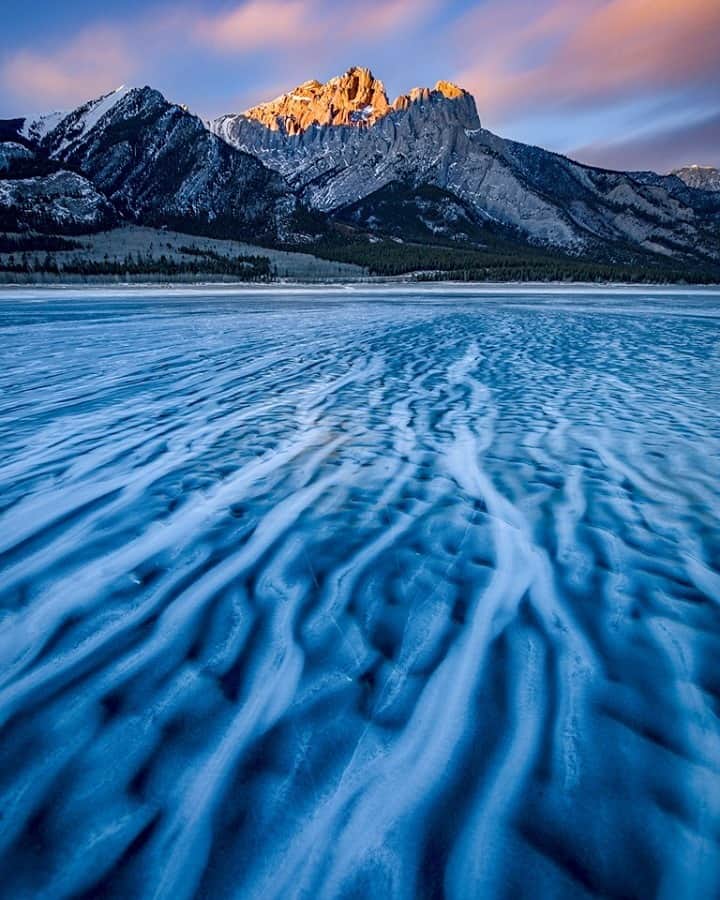 National Geographic Travelさんのインスタグラム写真 - (National Geographic TravelInstagram)「Photo by @kahliaprilphoto / Wind-formed ice patterns streak across the frozen lake, adding to the beauty of the mountain scenery here in the Canadian Rockies.」2月26日 8時35分 - natgeotravel