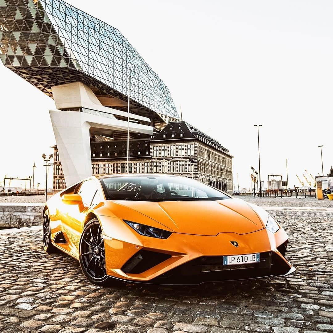 ランボルギーニのインスタグラム：「Huracán EVO RWD, just like the Port House designed by Zaha Hadid behind it, is the result of a complex interaction. The design of the Super Sports Car creates a delicate but nonetheless strong balance between technology, aerodynamics and fun. A combination that clearly shows how lines and angles can take advantage of the environment and make the most of it.  Captured by @momenol for @lamborghini_brussels.  #Lamborghini #HuracanEVORWD #RewindToRWD __ Huracán EVO RWD: Fuel consumption combined 13.8 l/100km; CO2-emissions combined 330 g/km (WLTP)」