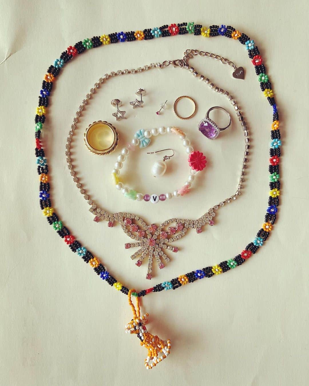 おおたうにさんのインスタグラム写真 - (おおたうにInstagram)「beads necklace / souvenir rhinestone necklace / Mom's "V" pearl bracelet / handmade pearl earring / Mom's lavender amethyst ring / ISETAN diamond pinky ring / @tiffanyandco  tiny ruby pierce / ISETAN diamond star earrings / @tiffanyandco  gold ring / @piaget  白の猫ちゃんスエットと、こないだ修理したchampionの白スエットパンツにカラフルニットソックスで新宿へ。古着白ジャージのセットアップの大人、しかも新宿、よく溶け込めます✨ アクセサリーは半分ポップにしたら、残りは本物を。子供時代から集めている「お人形ビーズもの」が活躍して嬉しい😊 #今日のアクセサリー #accessoriesoftheday #rhinestonejewelry #fashion」2月26日 13時06分 - outa_uni