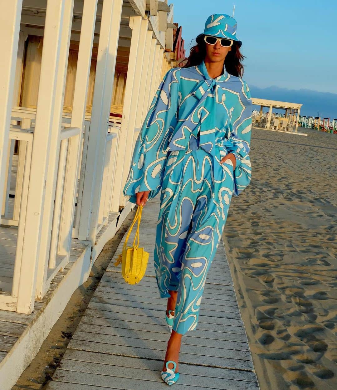 サラバターリアのインスタグラム：「...JOIE DE VIVRE  UNIFORM OF HAPPINESS SPRING SUMMER 21   Nicole wears the Bow shirt and Pants in Ocean with Plissè Bucket XS in Yellow color  Available on sarabattaglia.com and in the best stores  #SaraBattaglia #JoieDeVivre」