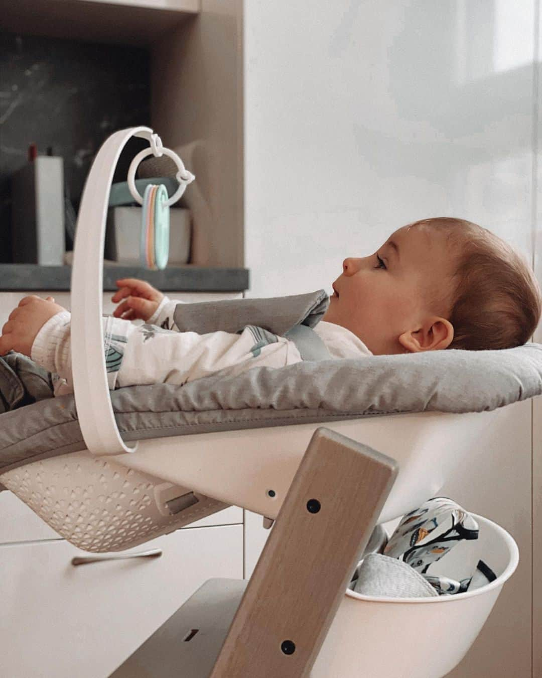 Stokke Japanさんのインスタグラム写真 - (Stokke JapanInstagram)「ニューボーンセットに下がっているおもちゃを興味深そうに見ている赤ちゃん。ちょっと家事をする間など、手の届くお子さまなら自分で揺らして遊んでもらえるのでとても便利です。このトイハンガーは、ニューボーンセットに付属していて、左右どちらでも付けられます。⠀ ⠀ ちなみに背板についている小物入れは「オーガナイザー」です。タオルやおもちゃなどを入れておけてこちらも便利。離乳食期なら、お口拭きやエプロンを置いておくのもおすすめです。⠀ ⠀ #ストッケ #ニューボーンセット #出産準備⠀ @thatblogthing」2月26日 21時00分 - stokkejapan