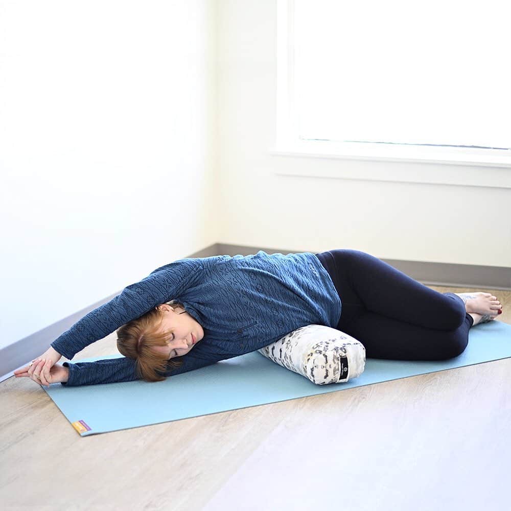 ハガーマガーのインスタグラム：「There really aren’t a whole lot of day-to-day tasks that require lateral bending. That’s probably why most people find side stretches in yoga so invigorating. The thoracic spine—the part of the spine that connects to the ribs—is designed to move this way. The facet joints (the articulations between vertebrae) come together in such a way that they slide easily over one another in lateral bending.   Lateral bending mobilizes your spine to prepare it for more challenging movements and can be woven into Restorative Yoga practice with a bolster. Practicing a supported lateral bend early in a Restorative session not only feels wonderful, but it also helps prepare your thoracic spine for other poses—especially for Restorative backbends such as Supported Setu Bandhasana (Bridge Pose) or Viparita Karani (Supported Legs Up the Wall), which are not so natural for the thoracic spine.   • LATERAL BENDING ON A JUNIOR BOLSTER •   1. Gather your props. You’ll need a Yoga Mat and a Yoga Bolster (We prefer to use a Junior Yoga Bolster for this pose.) You might want to add a Yoga Blanket, placing it over your yoga mat for extra cushioning.   2. If you’re using a blanket, fold it in half and spread it over the length of your mat.   3. Place your bolster across the center of your mat.   4. Sit on the mat so your hips are about 5-8 inches away from your bolster.   5. Lie sideways over your bolster, and extend your arms out overhead, laying your head on your bottom arm.   6. Move around to find a comfortable position. You may need to move closer or farther away from your bolster.   7. Stretch your arms out as you ground your hips. Stay for 5 to 10 deep breaths, and then push yourself up to a seated position.   8. Repeat on the other side.」