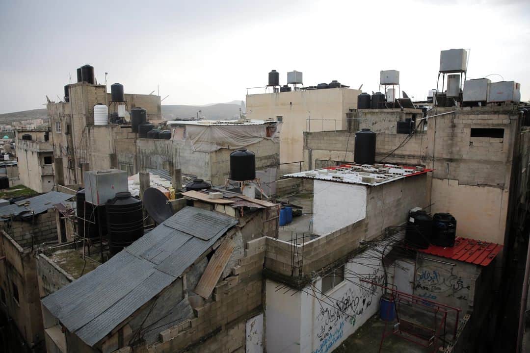 ルモンドさんのインスタグラム写真 - (ルモンドInstagram)「La lumière n’entre pas dans les venelles serrées de Balata, le plus grand camp de réfugiés de Cisjordanie, à l’entrée de Naplouse. Mais la pluie y glisse sans gêne, sans limite, charriant la terre et les ordures, renvoyant chez eux les jeunes hommes du quartier aux prodigieuses coiffures gominées. Les guetteurs armés de la police, invisibles sur les toits, peuvent baisser la garde.⁣ Depuis l’automne, Balata bouillonne. L’Autorité palestinienne (AP) multiplie les arrestations dans cette zone rétive à son contrôle, créée pour des réfugiés de la guerre de 1948, où 27 000 personnes se serrent sur moins de 1 kilomètre carré. Chaque incursion menace de dégénérer en échanges de tirs, et ça ne manque jamais : les jeunes hommes font émeute, se répandant sur les boulevards de Naplouse. Ici les armes ne sont pas tournées contre Israël – dont les soldats mènent eux aussi des arrestations régulières dans le camp –, mais entre Palestiniens. Tous se réclament du Fatah.⁣ Au sein du parti au pouvoir, les hiérarques s’écharpent à bas bruit, à l’approche des élections législatives et présidentielle prévues en mai et en juillet, les premières en Palestine depuis 2006. Le renseignement militaire israélien surveille cela avec inquiétude. Il y devine les prémices d’une lutte violente, au sein du Fatah, pour la succession du président Mahmoud Abbas, âgé de 85 ans, qui n’a pas d’héritier « naturel ».⁣ -⁣ 1-2 : Dans les rues du camp de Balata des affiches omniprésentes rendent hommage aux «martyrs», notamment Ahmed Abu Hamadeh (affiche du milieu) surnommé «Al-Za’bour», chef d’un gang armé mort en 2018 lors de sa détention dans une prison de l’Autorité palestinienne à Jéricho.⁣ 3-6-7-8 : Dans le camp de réfugiés palestiniens de Balata, à côté de la ville de Naplouse en Cisjordanie, le 23 février 2021⁣ 4 : Le gouverneur de Ibrahim Ramadan, à la sortie de son bureau à Naplouse, le 23 février⁣ 5 : Une entrée de la zone fortifiée du Fatah à Naplouse⁣ -⁣ Photos : Heidi Levine (@heidi_levine) #PourLeMonde⁣ -⁣ #fatah #Palestine #Naplouse」2月27日 6時20分 - lemondefr