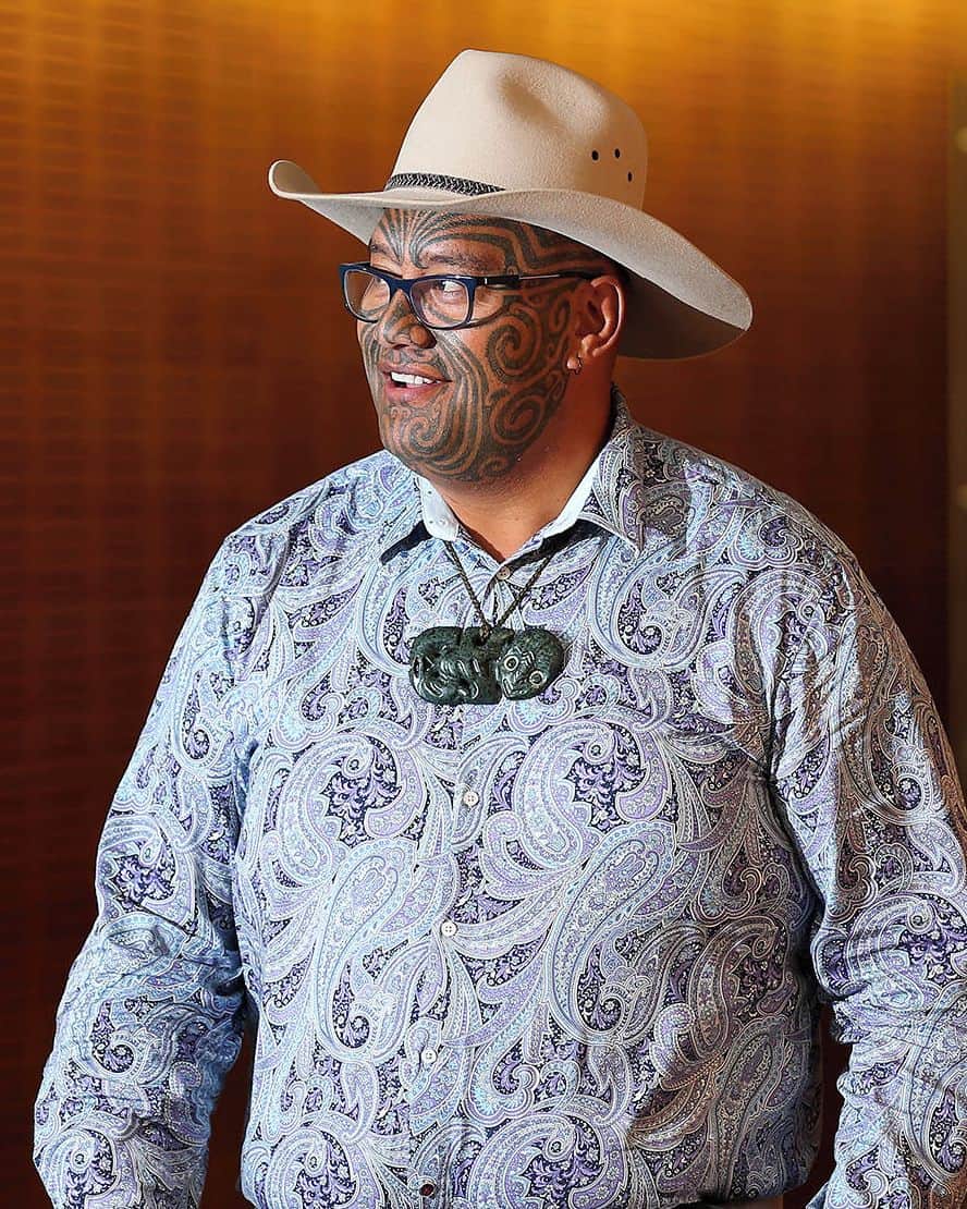 ルモンドのインスタグラム：「Le visage presque entièrement recouvert d’un tatouage tribal, toujours coiffé d’un chapeau de cow-boy en forme d’hommage au surnom de ses ancêtres engagés dans le bataillon maori durant la Seconde Guerre mondiale, le député Rawiri Waititi n’est pas du genre à passer inaperçu. Encore moins dans l’hémicycle du parlement néo-zélandais. « Vous savez ce que ça fait d’avoir un caillou dans votre chaussure ? Ce sera mon travail ici », a-t-il lancé, d’emblée, à ses pairs lors de sa première intervention, le 3 décembre, peu après son élection. Promesse tenue. Il a suffi d’une poignée de séances pour que, le 10 février, le coprésident du Parti maori obtienne l’abandon d’un règlement interne datant de l’époque coloniale : le port obligatoire de la cravate pour les hommes.⁣ Il a d’abord bruyamment ouvert le débat, début décembre, lors de son premier discours devant une chambre déjà surprise de le voir prendre la parole sans ôter son couvre-chef. Alors qu’il s’apprête à conclure, Rawiri Waititi, saisit sa cravate et fait mine de se pendre avec. « Enlevez cette corde autour de mon cou pour que je puisse chanter ma chanson », clame-t-il en citant le chef Mokomoko - un Maori exécuté à tort par les Britanniques pour meurtre en 1866. Le député se débarrasse alors du « nœud colonial » pour le remplacer par un hei tiki ; un pendentif de forme humanoïde symbolisant la fertilité, transmis de génération en génération et considéré comme un « trésor » par la communauté maorie. Le ton est donné.⁣ -⁣ Rawiri Waititi (@rawiri_waititi) au parlement à Wellington, en Nouvelle-Zélande, le 15 février 2021. Photo : Hagen Hopkins (@hagen_hopkins) / Getty (@gettyimages) / AFP (@afpphoto)⁣ -⁣ #NouvelleZelande #maori #cravate」