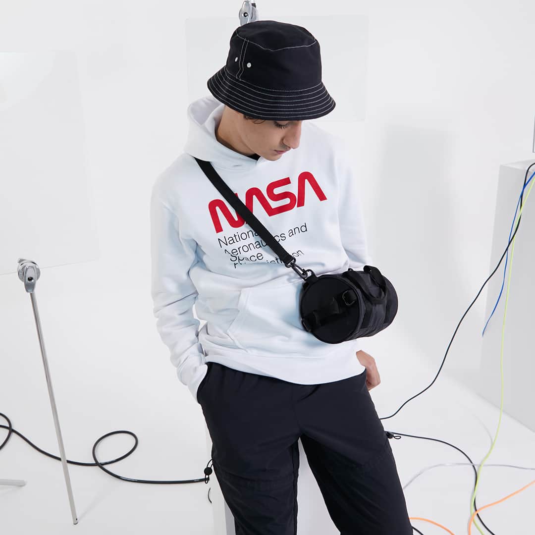 のインスタグラム：「Um novo olhar de 2021 para a moda dos anos 2000. Os moletons, acessórios e o visual tech estão de volta para nos inspirar! 👾 Venha conhecer essas novidades em looks masculinos no nosso site ou no app Renner. . . . #PraTodosVerem #PraCegoVer: sequência de duas imagens, uma após a outra, com fundo branco. A primeira foto mostra um modelo vestindo um moletom branco com estampa gráfica em vermelho e preto, um chapéu tipo bucket hat preto e uma bolsa arredondada preta. A segunda foto mostra o mesmo modelo vestindo a mesma combinação de peças, mas agora sentado em um banco branco e aparecendo também seu tênis preto com sola branca.」