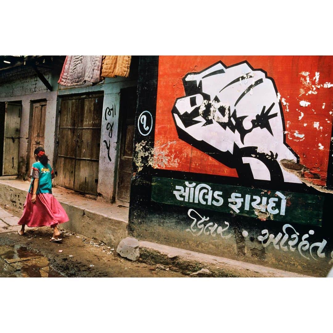スティーブ・マカリーのインスタグラム：「Girl walks past cement advertisement that reads "Solid Benefit", #Gujarat, #India, 1996.  #SteveMcCurry #SteveMcCurryIndia」