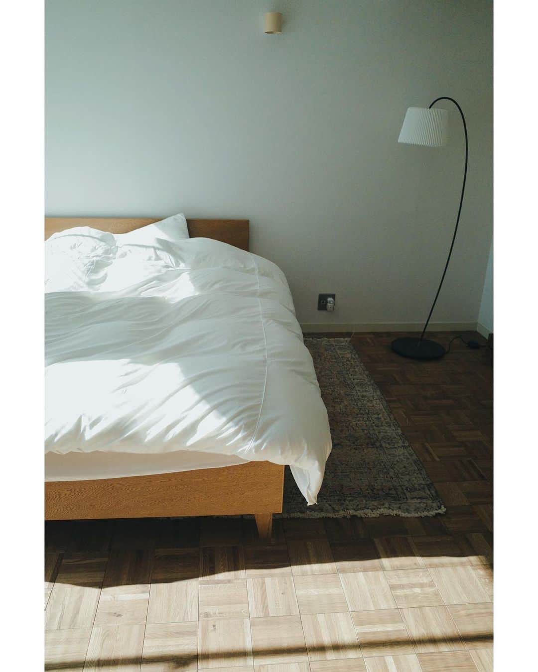 高山都さんのインスタグラム写真 - (高山都Instagram)「この家で好きな時間、好きな場所。 本当によく眠れるようになった。 そして、陽がのぼると自然に起きられるようになった。 ベッドは @pacificfurnitureservice  寝具は @nishikawa_co.ltd  フロアランプは @le_klint_japan  ラグは @reve_vintagerug  全然未完成で、サイドテーブルも欲しいしなーとか色々イメージは膨らむ。 床は、　@r_toolbox にリノベーションしてもらいました。 あ、葉っぱが生えてきて、声が出た。うれしい。芽吹きの季節が来たー。 #都の部屋の日々の記録」3月26日 8時52分 - miyare38