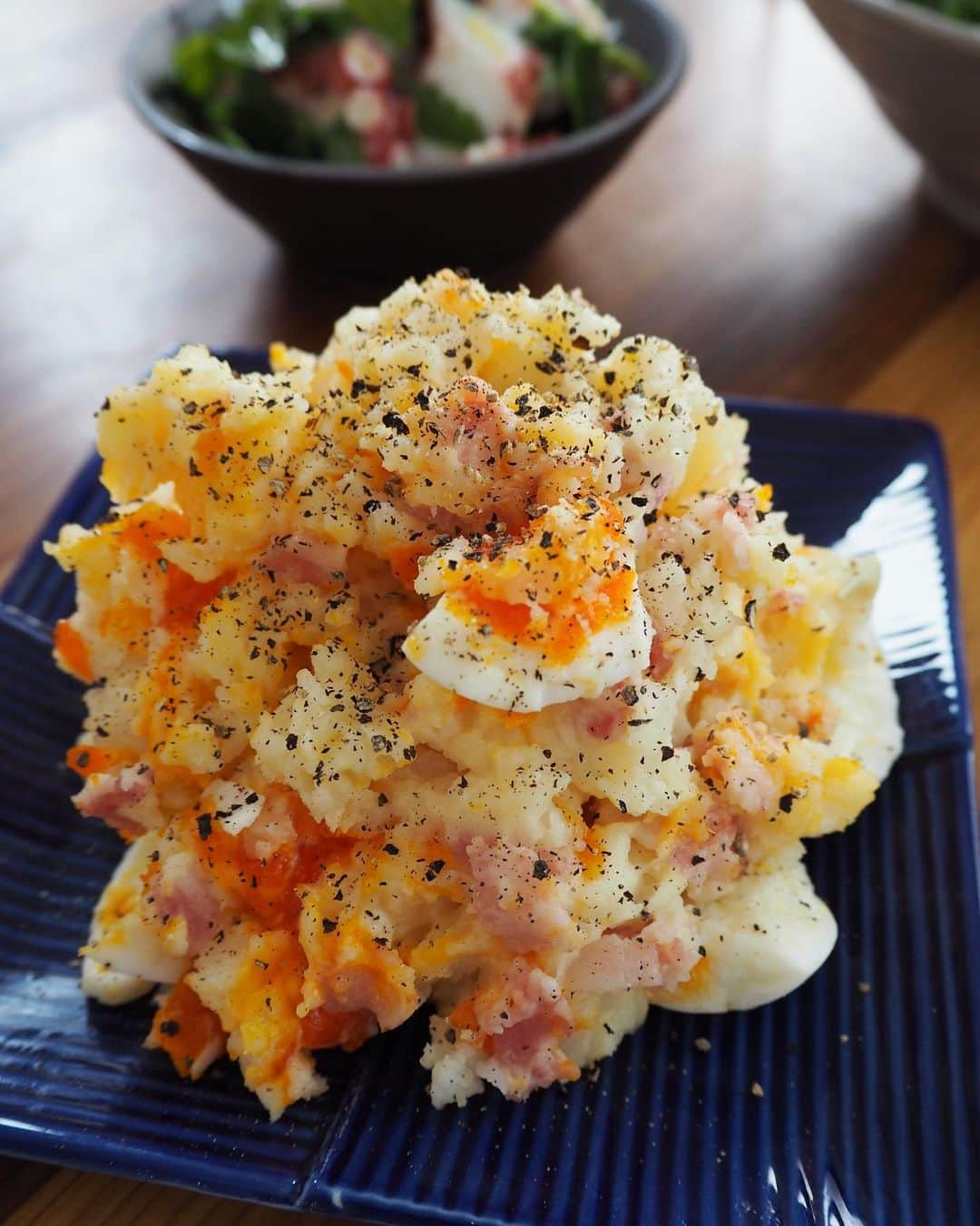 吉野千穂さんのインスタグラム写真 - (吉野千穂Instagram)「千穂飯レシピ🌿『半熟エッグポテサラ』  最近イチオシのポテトサラダ！ 食べてほしいし作ってほしい☺️ レンチンで作れてお酒にも合う味付けです🍻 (ビールか白ワインがおすすめ！)  「半熟エッグポテサラ」でweb検索すると 動画付きで作り方のってます！ (デリッシュキッチンのアプリでも😊)  🌱材料 じゃがいも　2個 ベーコン　2枚 半熟ゆで卵　1個 おろしにんにく　小さじ1 マヨネーズ　大さじ3 黒こしょう　少々  ⭐︎酢　大さじ1/2 ⭐︎コンソメ　小さじ1/2 ⭐︎塩　小さじ1/4  《下準備》 ・半熟ゆで卵を作る 小鍋にたっぷりの湯をわかし、冷蔵庫から出したての卵をおたまを使ってゆっく〜り(これ大事)入れる。8分茹でて冷水にとる。火加減はコトコトくらい。(ゆで卵の作り方は色々ありますがわたしはこのやり方がやりやすい。)   ①材料を切る ・じゃがいもは皮をむいて一口大に切り、水に5分ほどさらして水気を切る。 ・ベーコンは1cm幅に切る  ②レンチンする 耐熱容器にじゃがいも、ベーコン、おろしにんにくを入れてふんわりとラップをし、600Wのレンジでじゃがいもが潰せるくらいまで5分ほど加熱する。  ③調味料を混ぜる ・熱いうちに⭐︎を加えてフォークでじゃがいもを潰しながら混ぜ、冷ます。 ・冷めたらマヨネーズを加えてなじむまで混ぜ、半熟ゆで卵を加えてざっくり割りながらさっと混ぜる。  ④仕上げる 器に盛って黒こしょうをたっぷりかける。 * * #ポテトサラダ#ポテサラ#大人のポテトサラダ#ワインに合う料理#半熟卵#簡単レシピ#作り置き#作り置きレシピ#常備菜#千穂飯#管理栄養士ごはん#管理栄養士#吉野千穂#おうちごはん#毎日ごはん#朝ごはん#お昼ごはん#晩ごはん#今日のごはん#おうち居酒屋#おつまみ#おつまみレシピ#フードスタイリスト」3月9日 22時03分 - chiho_yoshino