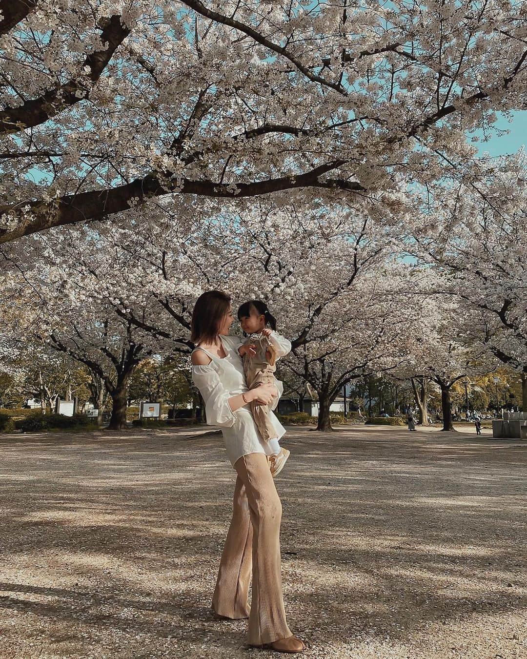孫きょうのインスタグラム：「この前公園で桜の絨毯で遊ぶ子供達がかわいかったなぁ🌸   new pants @titivatejp  このプリーツパンツ長めの丈なんだけどセルフカットして身長に合わせた丈に出来るの✨(そのままハサミでほつれない生地)  168cmの私はあえてノーカット。 高身長でも少しずるっと長めに履けるボトムってあまりないからヒールと合わせて足長狙えて嬉しい🥺✌🏽  #ootd #outfit #titivate #titivatestyle #ティティベイト #セルフカットフレアプリーツパンツ #春コーデ #ママコーデ #プチプラコーデ #プリーツパンツ」