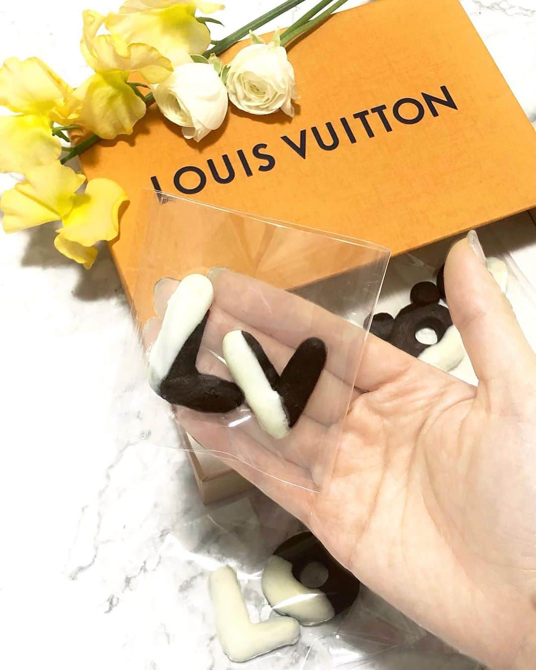 Manaさんのインスタグラム写真 - (ManaInstagram)「🍊🌼🍪🧡 𝑺𝒖𝒓𝒑𝒓𝒊𝒔𝒆 𝑳𝑽 𝒄𝒐𝒐𝒄𝒌𝒊𝒆𝒔! 急にお菓子のラッピングアイデアが浮かんだので、クッキーを作りました🥺💕 . ルイヴィトンの箱へ手作りLVクッキーを詰めて… . 「LV」の文字の下に隠された 「LO」と「VE」の袋を見つけたら 二度しあわせ♥️ . I made handmade Louis Vuitton cookies with a hidden message of “LOVE”. . . クッキーはビターカカオに ホワイトチョコをコーティングしました🐶💐 . . こういうものがあったらいいな〜と サプライズを考えるのが楽しいです💗♪ . 皆さんの理想の手作りサプライズはどんなものですか？🥰 . . . . . . #bittersweet #cookies #LV #louisvuitton #homemadecookies #coffeetime #homemadesweets #珈琲のお供 #手作りお菓子 #クッキー作り #サプライズ #サプライズプレゼント #プレゼント #ルイヴィトン #ヴィトンカフェ #おうちカフェ #料理上手になりたい #料理好き #料理女子 #料理記録 #隠れミッキー #簡単スイーツ #栄養補給 #楽しく補食 #おやつの時間 #ヘルシーメニュー #ヘルシースイーツ #料理研究家 #管理栄養士」4月11日 13時46分 - mana.tcy