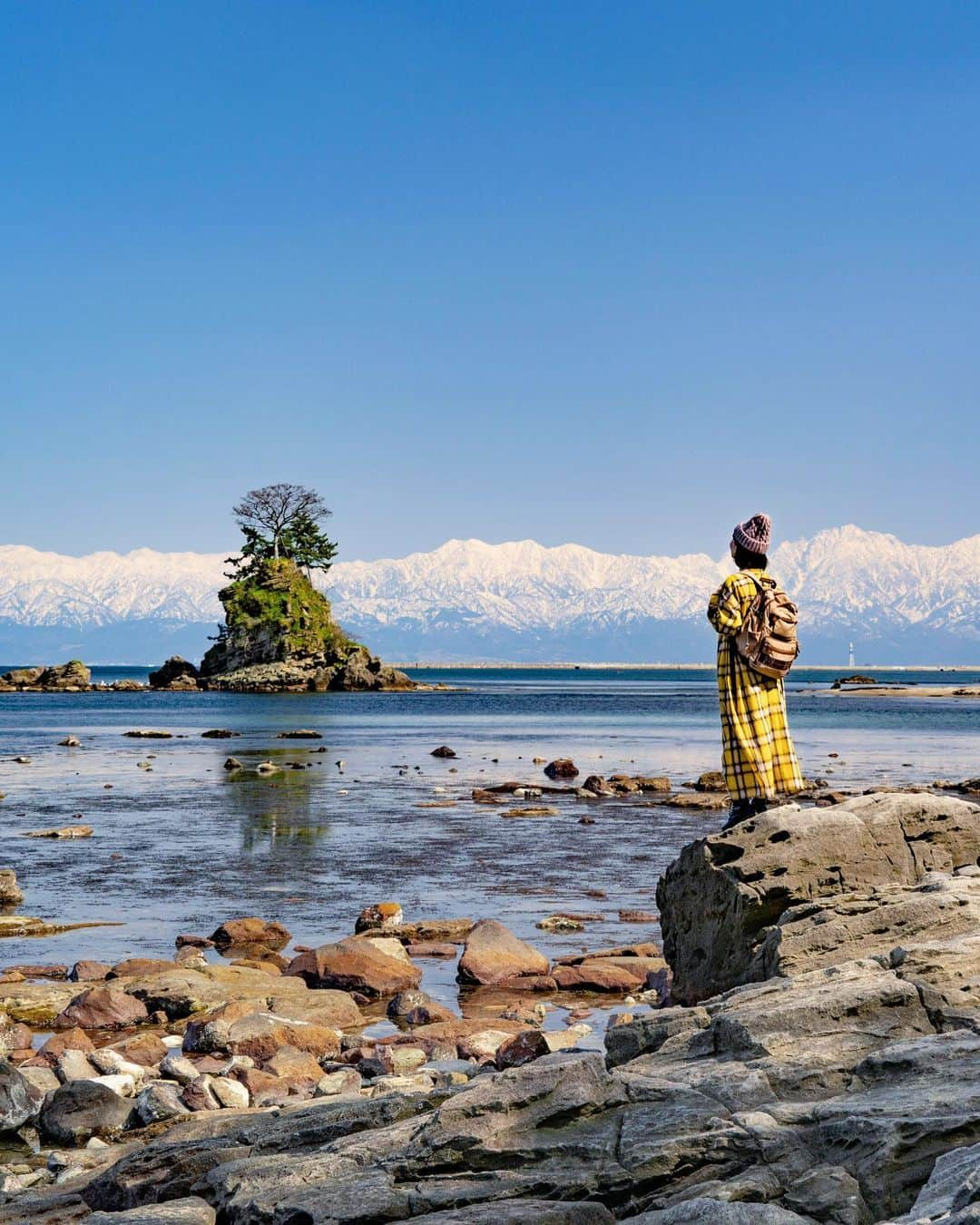 詩歩のインスタグラム：「Tateyama Federation over the Sea of Japan!  It is said that this is the only place in the world where you can see a 3,000m high mountain from 0m above sea level. There are few days when you can see the summit clearly, but I finally found this view on my third visit.  The name "Amaharashi" actually comes from Minamoto no Yoshitsune. There is a rock called 'Yoshitsune Iwa' on this beach, and legend has it that Yoshitsune took shelter from the rain here when he was fleeing to Hiraizumi. By the way, the rock in the picture is called "Onna-iwa" because the surrounding small rocks look like children!  The second photo is a view of #Uchikawa, close to Amaharashi Beach. It was nice and nostalgic to see the houses lined up along the canal! I hope you enjoyed this post on my trip to the Hokuriku area.  Did you enjoy it? I've put together a summary of my travels under the tag #shiho_hokuriku so I hope you find it useful!  🗻  富山から日本海越しに眺める立山連邦✨  海抜0mから標高3,000m級の山が見られるのは、世界中探しても実はここだけとか。雨晴海岸からスッキリ見える日は少ないのですが、3度目の訪問でようやくこの景色に出会えました👏  「雨晴」は「あまはらし」と読むのですが、その名前の由来は実は源義経から来ているそう。  この海岸には「義経岩」という岩があって、源義経が平泉に逃げるときにここで雨宿りをしたという伝説があるとか。（写真には写っていません）実は前回わたしが来たときは雨晴海岸で急にヒョウが降ってきたので、偶然にもこの義経岩で雨宿りをした経験もあるのでした☔  ちなみに、写真に写っている岩は「女岩」で、周囲の小さな岩たちが子供のように見えることから呼ばれているそうです👶　岩の名前って面白いよね〜  2枚前の写真は、雨晴海岸からも近い #内川 の光景。運河沿いに民家が並ぶ光景もノスタルジックで良かったな〜📷  さて、しばらくお届けしてきた北陸3県の旅。お楽しみいただけましたか？  #shiho_hokuriku のタグでまとめているので、ぜひ旅が再開したら北陸旅行の参考にしていただけたら嬉しいです✨  🙏旅行を検討中の方へ﻿ 緊急事態宣言解除後も、引き続き感染症対策は必要です！  政府や自治体が発表している新型コロナウイルスの最新情報を確認し、遠方の感染拡大エリアへの訪問は控えるなどご自身で判断をお願いします。﻿#withコロナ旅行 での感染対策方法についてはyoutubeに動画をあげています。  @panokito_toyama @michinoeki.amaharashi  📷 2021 📍雨晴海岸／富山県 　高岡市 📍Amaharashi Coast／Toyama Japan #shiho_toyama  ©詩歩 / Shiho」