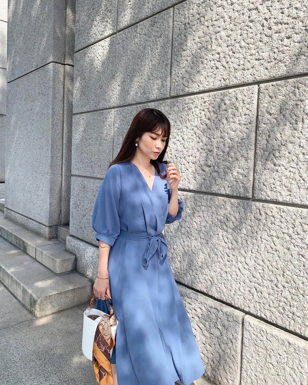 吉田奈央のインスタグラム：「ワンピの色に一目惚れ💙←  ブルーでもこのブルーはありそうで中々なかった色なのよ。 くすみブルーでもキレイめだから顔も明るく見せてくれます😍  @fifth_store のなんだけどシワもなりにくい、とろみ素材だから高見えもしてくれて本当に優秀アイテムです←  ウエストリボンは別々だから、無くても ゆったりめでカジュアルにも着こなしできそうだよ！ スニーカーで合わせたら可愛いだろうな👟🧡  今回は白バッグに柄スカーフを巻いて上品さをupしました🌹  ＊  #fifth#fifthtl#フィフス#ウエストリボン付きカシュクールワンピース#フィフスタイル#ブルーコーデ#プチプラコーデ#きれいめコーデ#上品コーデ#アラサー女子#大人ワンピース#30代ファッション#ママコーデ#ママファッション#着回しアイテム#スカーフアレンジ#スカーフコーデ#男の子ママ」