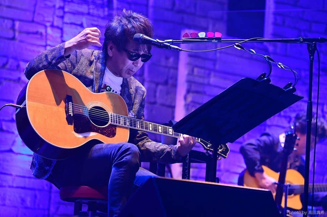 木根尚登のインスタグラム：「「スタッフ」こと「KINEのとなりの人」です🕶「K-FOLK 2021」にご来場、ご視聴くださった皆様ありがとうございました！  昨年末、冬の星座の下、三人のステージが実現しましたが🌌今回は、春の風に戯れて、二人だけの別のステージとなりました😎🕺  木根尚登がステージで「ある意味K-FOLKも宇都宮隆プロデュース」と言っていました。  先日は渡辺美里さんから「木根ちゃんと一緒に木根ちゃんの曲を演奏する木根ちゃん祭りを！」と、スタジオライブへの出演オファーを頂きました🌸  K-FOLKも、スタジオライブも、木根は、全体リハーサル以外に個人練習にも沢山の時間を費やしていました。  自分一人のソロライブでは、自分の思いのままにステージを表現する事が出来ます。対して、請われて出演するライブは、当然の事ながら、プロミュージシャンとしてオファーに応える責任があり、それが興行の成功を大きく左右します。  『幼馴染み、旧友の顔に泥を塗るわけにはいかない』と。  そんな一生懸命な姿を、多くのウツさんファンや美里さんファンに観て聴いて頂ける機会を頂いて嬉しく思います。  となりの人としては、日頃から、いつも木根尚登を応援してくださっているファンの皆さんへの感謝の気持ちは尽きません🙇‍♂️木根尚登が木根尚登の曲を歌うソロライブを待っていてくださっている方もいらっしゃると思います。  木根ソロライブは、昨年ツアーを全日程中止して以来ストップしたままです。実は、大変ありがたい事に「木根さんのソロライブを是非うちで！」といったオファーを頂くこともあるのですが、その度に木根が口にするのは「ソロライブは、自分発信で再開させたい、しっかりと自分でつくってファンに届けたい」と。  今も尚、全国のライブハウスや音楽事業者は大変な状況ですが、それは応援してくださっているファンの皆さんも同じ事と思います。再開、再会への道は平坦ではないと思いますが、出来る事をひとつひとつ積み重ねていきたいと思っています。  K-FOLKでは、企画立ち上げから本日の配信終了日まで、何百人というプロフェッショナルたちのご尽力によって木根尚登はステージに立たせて頂いた事をここに記させて頂いて、改めて感謝申し上げます。  #罰ゲームは二人だけの遠い過去の約束だと瞳を閉じて木根が言った #トライアングルに思いをめぐらした」