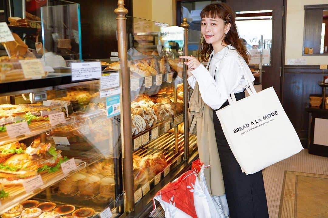 山野ゆりのインスタグラム：「パンの中でも一番好きなのがバゲット🥖✨バゲットを持ち運ぶ専用のトートバックが欲しくて @breath_topkapi さんとコラボして【パン野ゆり×Breath TOPKAPI】ブレッド・ア・ラ・モード トートバッグを作りました🥖♡  今回どんなトートバックにしようかな？と考えている時に、まず大好きなバゲットが縦型に収納できる仕切りをつけたい ！という事。（バゲットだけじゃなくて縦型なのでタンブラーやこれからの季節は折り畳み傘なんかも収納しやすいです♡　　  そしてエコバックよりも耐久性があり持ち手がよれないという事！その２つは外せないポイントとして作らせて頂きました🍞（持ち手は短いのと長いのと2wayなの♡  前面にプリントした「BREAD A LA MODE」というのは造語なのですが、元々プリン・ア・ラ・モードという言葉がとても可愛い響きだなぁと思っていて。🍮🍮🍒♡  意味を調べたところ、ア・ラ・モードというのは「洋菓子や果物などにアイスや生クリームを添えた物」という意味と、「流行の」や「現代風の」という意味がありました。  コロナ禍において、お家で過ごす時間が増えた今、パン屋さんに足を運び、手軽においしいパンを購入することが以前よりも生活に馴染んでいる方も多いと思います。そんな背景から「現代の、流行りのパン」の在り方を考えた時にエコバックやトートバッグの普及がすぐ頭に浮かびました🥖  「自分のお気に入りのトートバッグにお気に入りのパンを入れて、パンを持ち運ぶ」。これって現代風のパンの在り方だなぁ！と思い、ブレッド・ア・ラ・モードの言葉を添えています♡  2色展開でベージュもあるんだけど、パン色ですごくお気に入り。サイズも大きめなのでパン好きな男性の方にもオススメです🥖✨私も又コーディネートして載せてみます♡  プロフィール欄にURLを貼ってあるので是非気になった方はチェックしてみて下さいね🥖  あと！ロケをさせて頂いた @viron_brasserie のバゲットは何度食べても最高だ🏅✨✨  #バゲット#🥖#パン#パン好き#パングッズ#トートバック#これ持ってパン屋さん行くよ#viron」