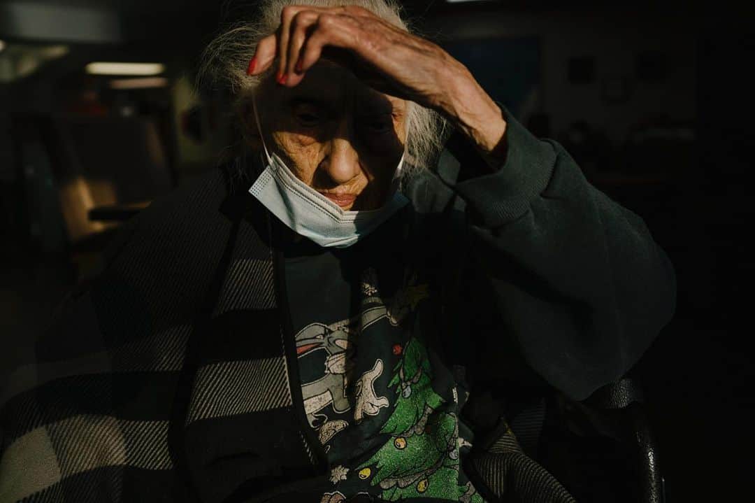 National Geographic Creativeのインスタグラム：「Photo by @isadorakosofsky   Mary sits in the communal area of the memory care unit at a skilled nursing facility in Albuquerque, New Mexico.   Studies estimate that the mental health fallout of the pandemic will be three times the medical footprint. Psychologists have seen an elevated rate of grief, depression, and anxiety amongst long-term care residents after a year of isolation and loss of community members. Clinicians working with individuals with dementia and Alzheimer’s Disease have noted changes in mood and declines in cognition. While vaccinations have allowed residents to reunite with their families, some states, like New Mexico, have set guidelines that encourage outdoor and scheduled visitation only. In New Mexico, 4,264 long-term care residents contracted Covid-19 and 997 died from the virus since March 2020.   To follow the development of this forthcoming story, and to see more stories about the impact of the pandemic on adults with disabilities and senior citizens, follow me @isadorakosofsky」