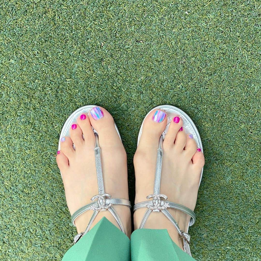 磯部奈央のインスタグラム：「Foot nail♡ . 冬は自分で適当にペディキュアするだけだけど、夏になるとサロンでフットネイルしてもらいます💕 . 今回アートの部分を、白地に濃いピンク＆パープル＆ターコイズブルー＆メタリックの色を、ランダムに縦に入れてもらって、派手ネイルに😊 お気に入りです♡ . そして、去年買ったサンダルもやっと履けた🙌🏻☀️ . . . #フットネイル #ネイル #シャネルサンダル」