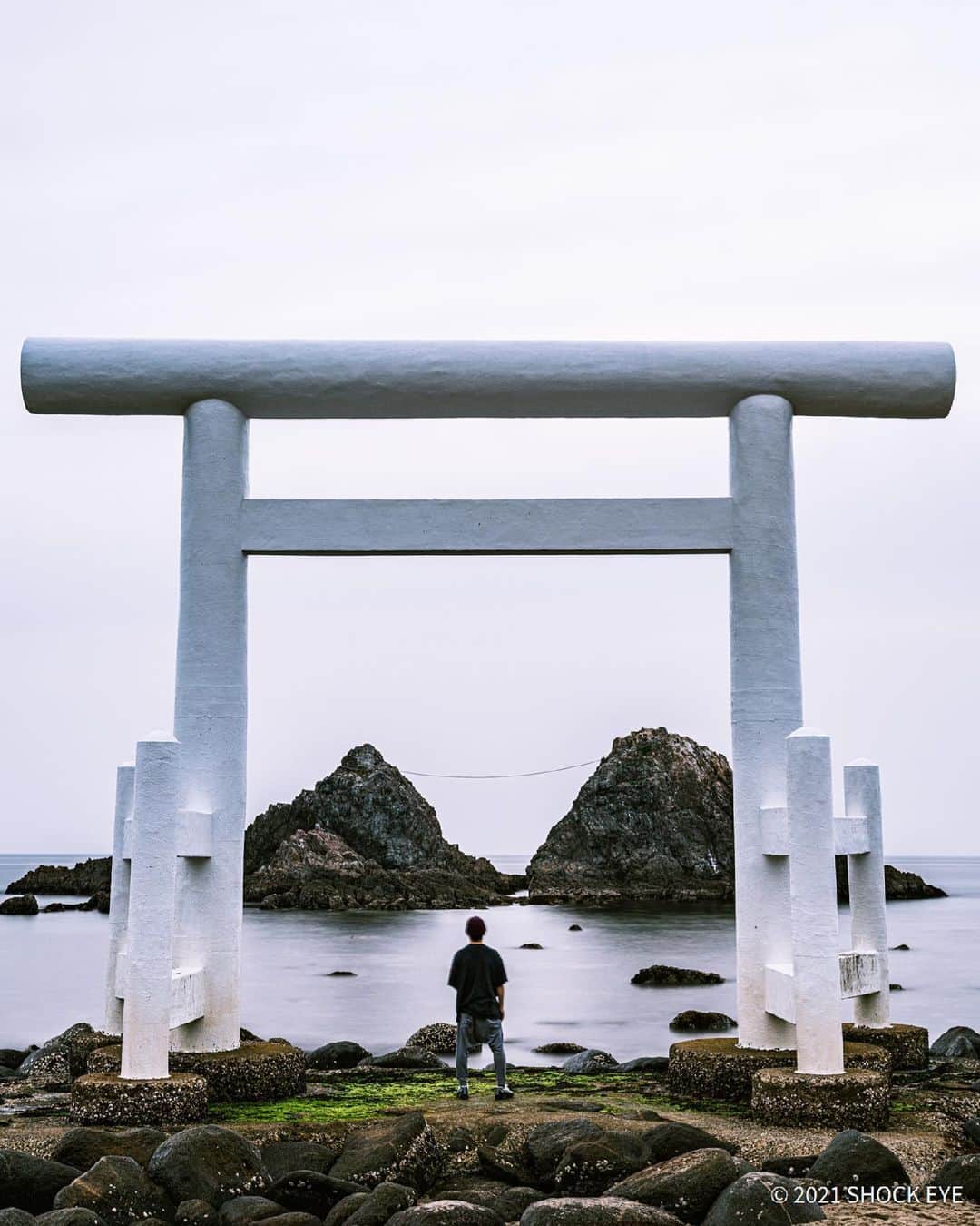 SHOCK EYEさんのインスタグラム写真 - (SHOCK EYEInstagram)「福岡糸島の櫻井二見ヶ浦に夫婦岩に向かって立つ純白の鳥居がある。 夏至の頃にはこの夫婦岩の間に夕陽が沈む絶景ポイントとしても有名だよね。 僕が行った日はあいにく曇りだったけれど、誰もいない静かな浜辺、、波の音しか聞こえないシーンに迫力のある鳥居と夫婦岩、、 不思議な時間だったよ🙏✨ 癒された〜🙏  #二見ヶ浦夫婦岩 #二見ヶ浦 #櫻井神社 #神社 #福岡 #糸島」5月28日 8時56分 - shockeye_official