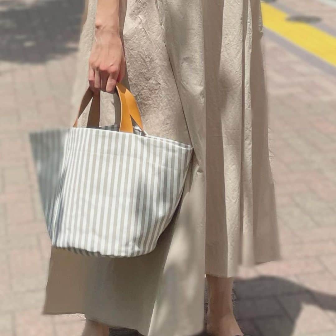 乙黒えりのインスタグラム：「ストライプトートバッグ @mart_select_shop_official で販売している　@blanc_official.jp とのコラボバッグ、グレージュです。 何にでも合わせやすいカラーになっていて、丸底で安定して物が入るし、ちょっとのお出かけにちょうどいい内容量です✨  手持ち部分がレザーになっているので丈夫ですよ！  ピンクのバックリボンブラウスも数枚再入荷しましたので、是非前回買えなかった方は今のうちにチェックしてみてください。 #ストライプトートバッグ#トートバッグ#ママファッション#ママコーデ#ミニトート#バックリボン#ピンク#グレージュ」