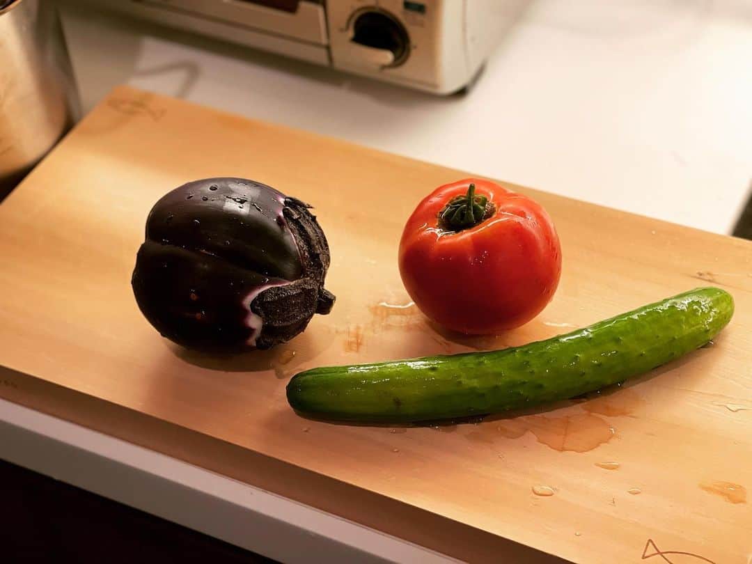 のインスタグラム：「世界一美味しい茄子と言われるイタリア茄子。挽肉と香味味噌炒めにしました。 香味野菜は長葱、生姜、大蒜のみじん切り。 茄子を高温の油で炒めて取り出し、香味野菜、挽肉の順に炒めます。ぬた用に作りおいたマイルドな白玉味噌と、香辛料たっぷりの中国辣油を加えて味をつけ、茄子を戻し炒めるだけ。 枝豆は鮮度が落ちるのが早いので、枝付きのものが冷蔵便で送られて来ました。すぐに、たっぷりの塩を入れた湯を沸かして茹でます。 炊き込みごはんは山伏茸と黒鮑茸。穏やかな出汁で茸を一煮立ちさせて濾した出汁でお鍋でお米を炊き、米肌が見えたら茸を合わせて仕上げます。 残った白玉味噌は胡瓜と昔ながらの品種のトマトにつけていただきます。 古川原農園夏野菜シリーズ。」