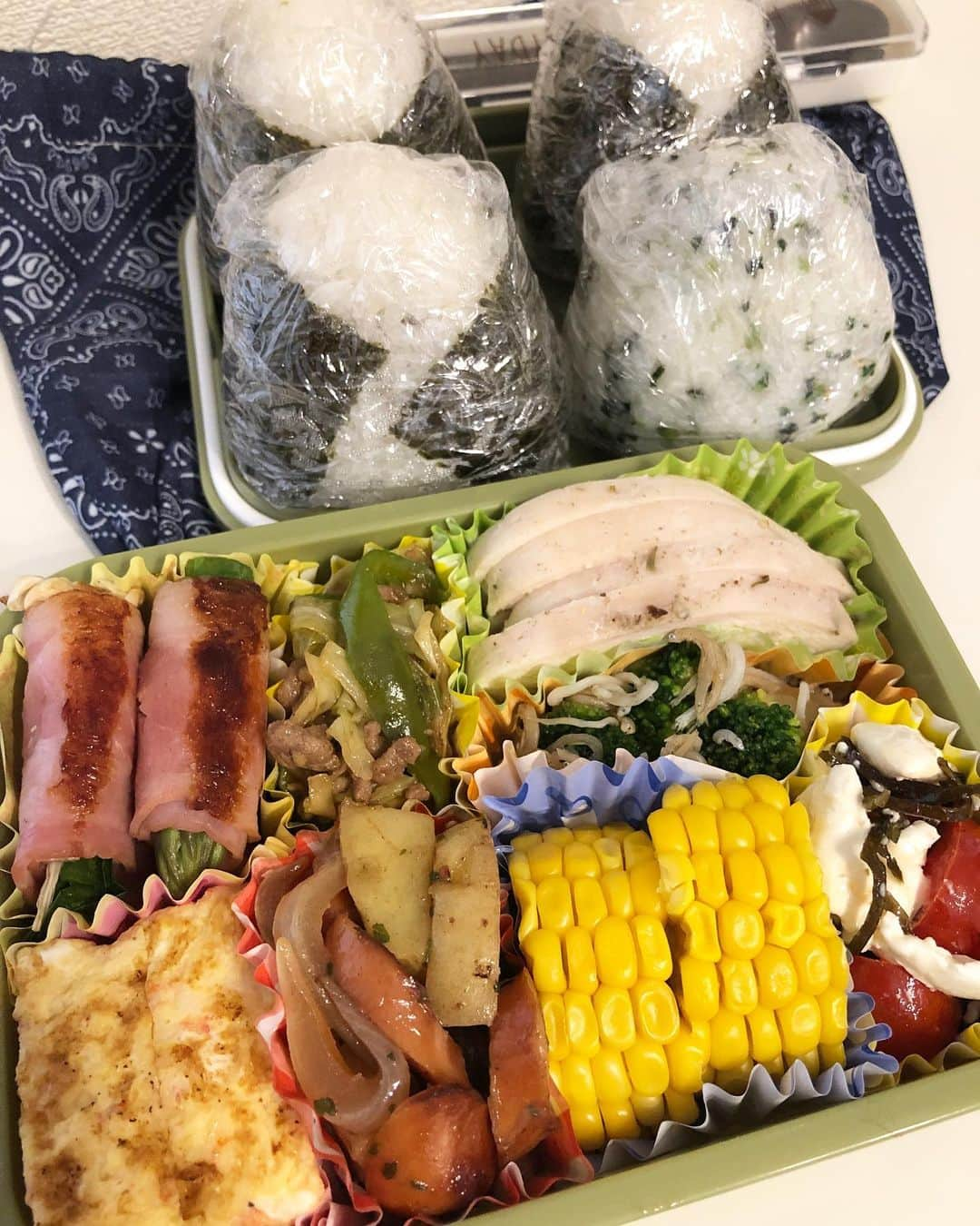 神咲詩織のインスタグラム：「・ ・ ・ ・本日のお弁当🍽👨🏽✨ ・ ・ ・アスパラベーコン巻き&ニラえのきベーコン巻き ・キャベツ、ピーマン、ひき肉のスタミナオイスターソテー ・鶏胸肉の自家製サラダチキン(ハーブソルト味) ・ブロッコリーとしらすのお浸し ・カニカマの玉子焼き ・ウインナーのジャーマンポテト ・塩茹でとうもろこし(安西農園さんの味来🌽) ・ミニトマトとクリームチーズの塩昆布和え ・おにぎり4種(明太子、鮭、塩昆布、わかめご飯) ・ ・ ・ ・引き続きセンチョクさん(@senchoku )のお野菜(アスパラ、ニラ、キャベツ、ピーマン、とうもろこし)を使って😌✨ ・ ・ ・ ・晩ご飯にも使わせていただいたけどそれはまた次で🕺 ・ ・ ・本日はとうもろこしの味来ちゃんを塩茹でしてみました🌽 ・ ・ ・生でも感動の甘さだったけど茹でるとじゅわじゅわジューシーになって少しまろやかになってこれまた美味しい🥺 ・ ・ ・そういえば最初にとうもろこし茹でて冷やしておいてたんだけどすっかり存在を忘れてしまってて ・ ・あれ？1品足りんくないか？！🤔 ・ ・ってなって急遽超絶簡単かつ時短なジャーマンポテト作ってから茹でとうもろこしの存在思い出したからおべんとばこギュウギュウになっちゃった🤣 ・ ・ ・(入らないから玉子焼き1切ぱくりと食べちゃったのは秘密🤫笑) ・ ・ ・そういえば可愛い可愛い妹ちゃんがおべんとづくりを始めるそうで(旦那様に)色々と聞いてきてくれてそれまた可愛くてお姉ちゃんなんでも教えたげるわよーってなってました🕺 ・ ・ ・私のお弁当メニューは割とレンチンとか常備食材とか作り置き冷凍とかをフル活用してるので簡単だし時短なのです🙌 ・ ・タッパーとか耐熱ボールとかラップ必須！ ・ ・ ・また簡単なもののレシピなんかも載せられたらいいなあ😌✨ ・ ・ ・ ・では🕺 ・ ・ #居酒屋こあら #おべんとこあら #お弁当 #自炊 #👨🏽 #妹大好きな姉」