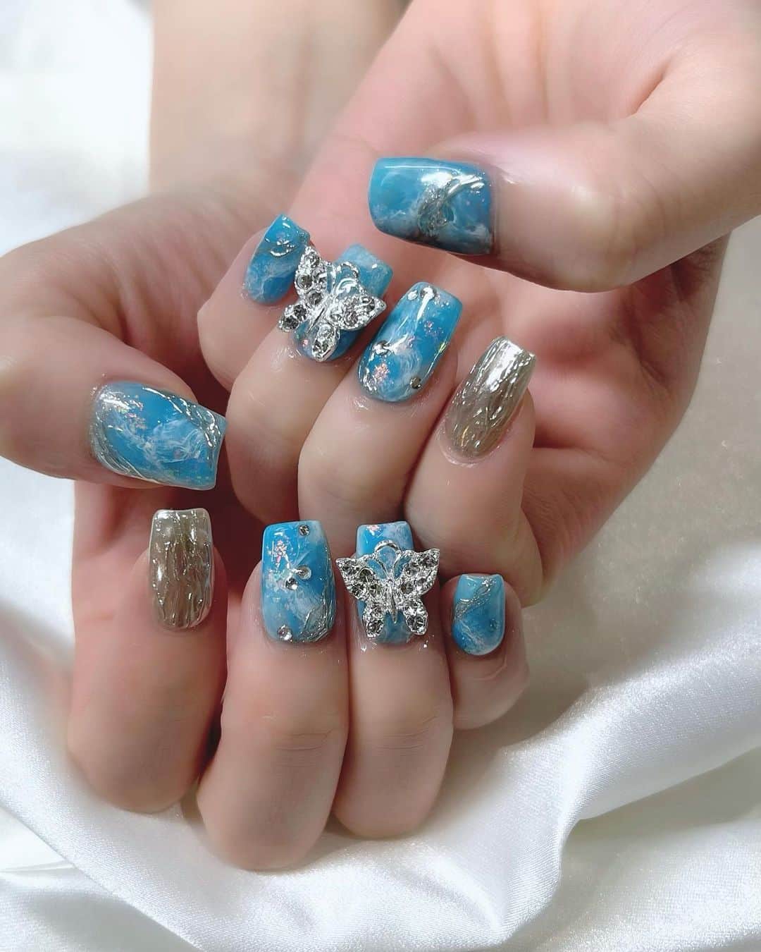のインスタグラム：「. ライブにむけてネイル💅を キラキラにしてましたぁ🦋💕 コメント見ると気付いた方おったね！ 客席遠いのにすごーい❤️  やっぱりネイルはテンション上がるね♩  今回は 水色×白の中にオーロラのキラキラ仕込んだけん 青空と夕焼けみたいな感じで仕上がりました🌇伝わる？笑 ・‥…━━━☞・‥…━━━☞ #ジェルネイル #ミラーネイル #キラキラネイル #ブルーネイル #夏ネイル #ネイルデザイン  #れーなネイル #lapis #photo #Instagram #instagramjapan  @lapis_kotoko さん いつもかわいいネイルありがとうございます♡♡♡」
