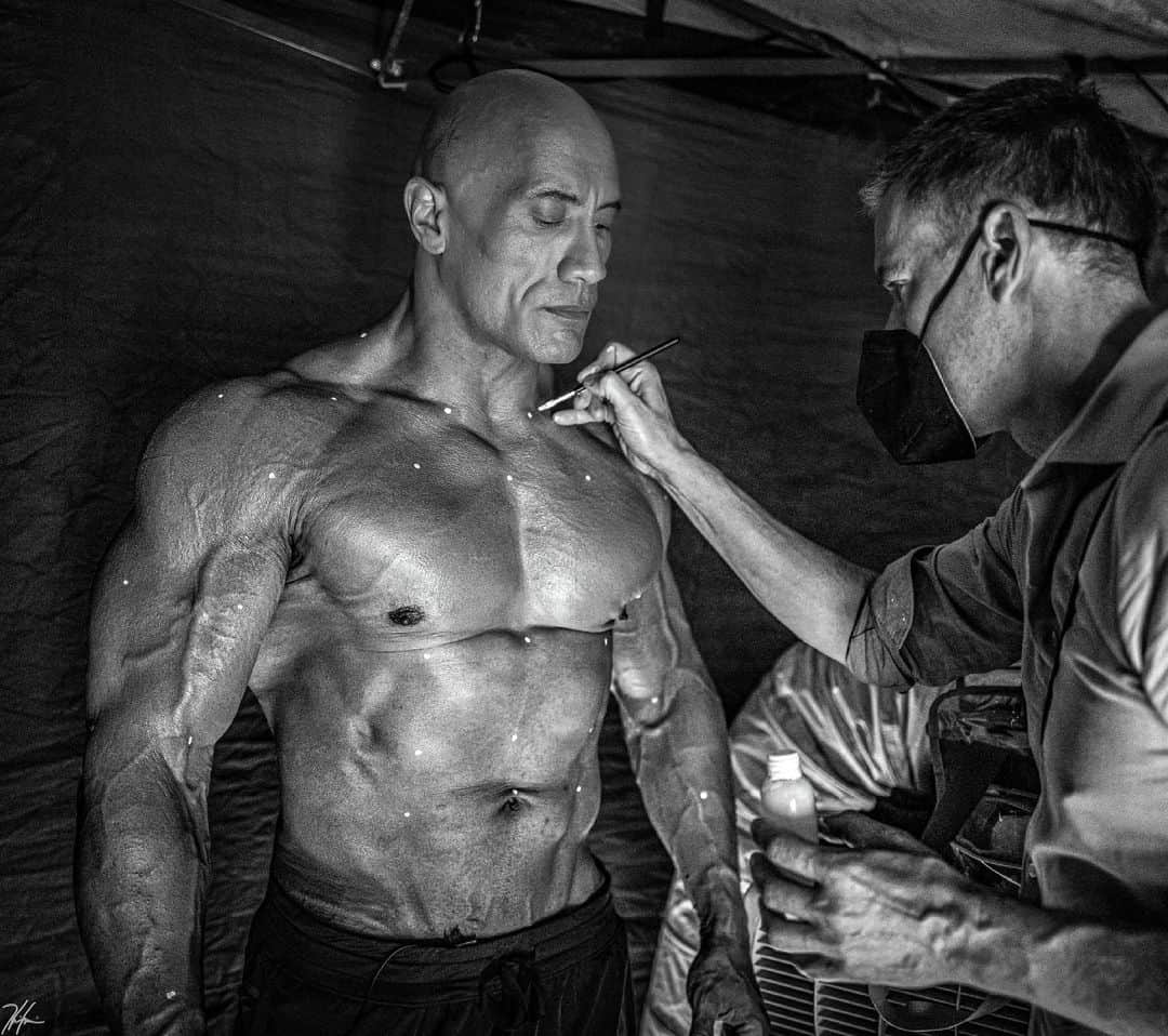 ドウェイン・ジョンソンさんのインスタグラム写真 - (ドウェイン・ジョンソンInstagram)「Minutes away from shooting a very cool cutting edge scene for our movie, BLACK ADAM⚡️  My skilled make up artist, Bjoern Rehbein is applying tiny white tracking dots to very specific areas of my body (legs included) so our Visual Effects team track and compute my muscle fibers intensely activating and moving while BLACK ADAM is raging to seek & destroy his enemies.   This is the final week of production and the hard work with my training, diet and conditioning has been relentless - hardest of my career because I’ve had to maintain this physical look for months and had to peak in my final week - but our collective goal is to raise the bar with BLACK ADAM.  To deliver the antihero you’ve been waiting for and you deserve.   Final week of production.   The hierarchy of power in the DC UNIVERSE is about to change.   Do not go gentle…   #blackadam⚡️ #rage #raisethebar  📸 @hhgarcia41」7月8日 14時48分 - therock