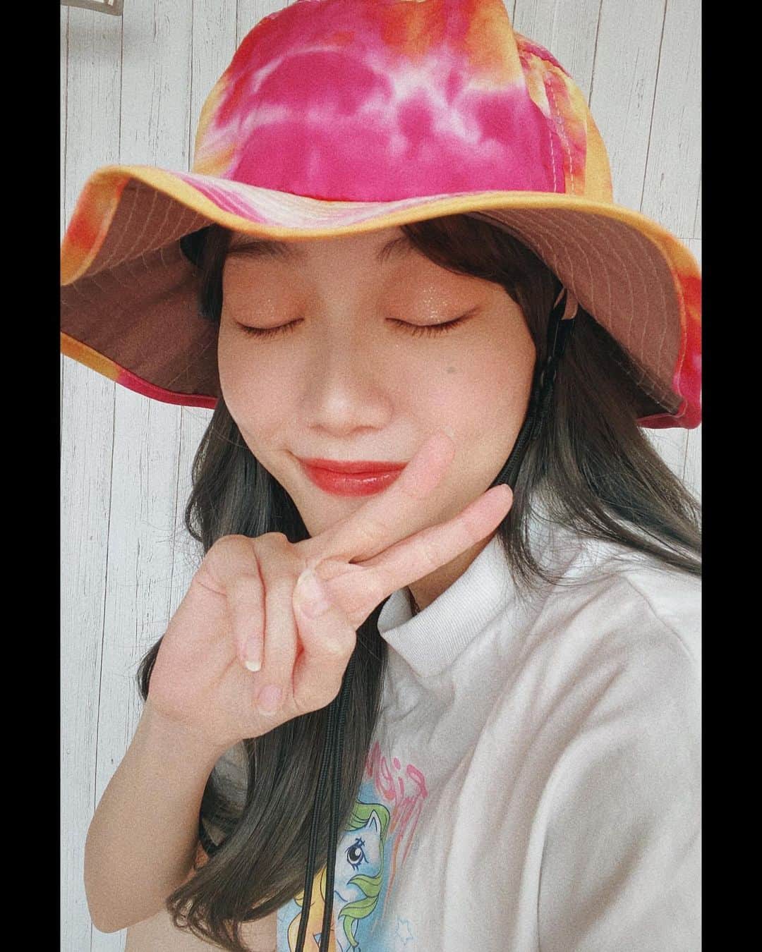 菜々香のインスタグラム：「とびっきり派手な帽子が届いた 🧡🍧️🐠👙☀️  夏ですね〜☀️  撥水加工されているから汗にも強い。  最近ダイダイが気になります🧐 #キラキラアイシャドウ #太陽に当たってキラキラ #タイダイ柄 #紐付きハット」