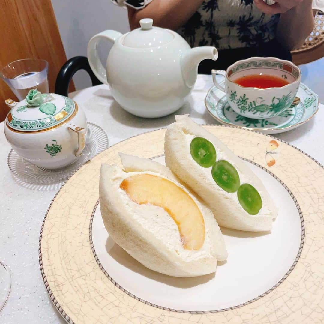 ERYさんのインスタグラム写真 - (ERYInstagram)「オーガニックのティーサロン、メゾンドエル @maison.de.l_teasalon に行ってきましたー！ 表参道に先週オープンしたばかりの綺麗なお店で、フルーツサンドもイートイン、テイクアウト共にOK！ 私は桃、一緒に行ったシンガーのmanamiはシャインマスカットをオーダー。 この日は他にもいちじく、パイナップル、キウイ、みかん、バナナがありました。 マンゴーは大人気の様で売り切れだったので、食べたい種類がある場合は予約した方が良いかも。  紅茶は「大人の贅沢ゴロゴロフルーツティー(1500円)」を。 スッキリしているけどフルーツの甘みが丁度良く、この季節の火照った身体に染み渡る美味しさ…入っているフルーツは日によって変わるそうで、今回はシャインマスカットとオレンジがたっぷり、輪切りのレモンが入っていました。  フルーツサンドは食べやすい様にと半分にカットしていただけるので、今回みたいに友達同士で頼むと半分ずつシェア出来て最高。 パンは薄めでふわふわ、クリームも多すぎない絶妙な量と甘さでフルーツとよく合います。 紅茶、フルーツサンド共に入っているフルーツのクオリティが高く、ここ最近ずっとあった「美味しいフルーツを食べたい欲」が完全に満たされました。笑 また行きまーす！ 場所は表参道のアップルストア裏手にあるとんかつまい泉の近く。 #maisondel #メゾンドエル #表参道カフェ #表参道ティーサロン #オーガニックティー #フルーツサンド」8月10日 10時59分 - bass_ery