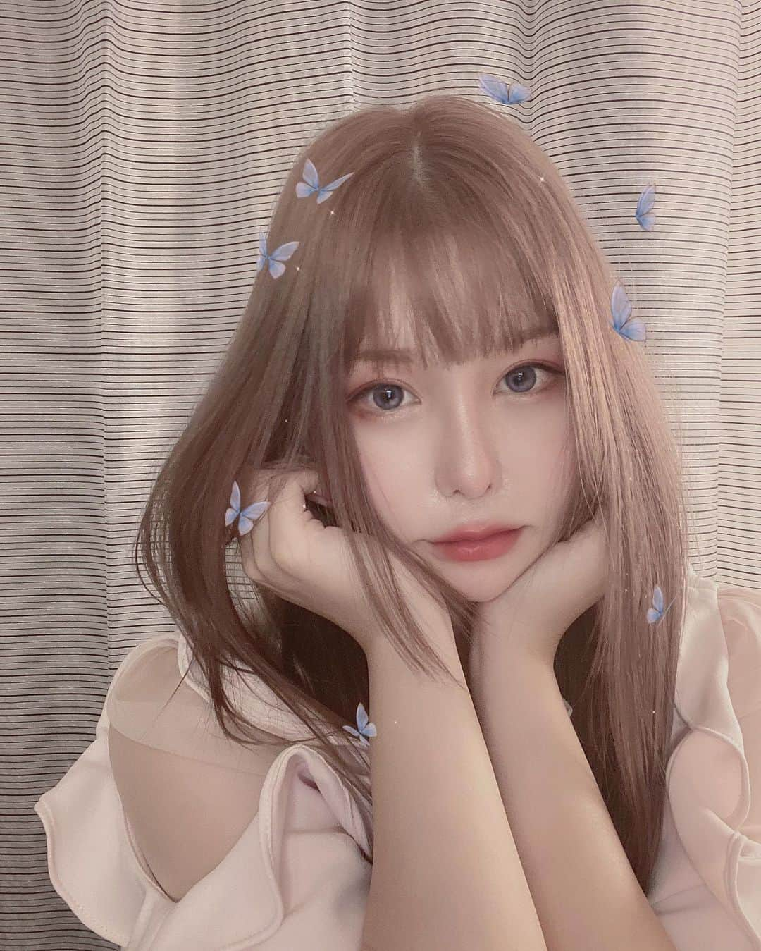 利咲さんのインスタグラム写真 - (利咲Instagram)「いめちぇん🧚‍♀️🌹🦋 →Pink hair color 前髪切ってピンクヘアにしました💗 ストーリーのアンケートを参考にしたのでみなさまのご意見が反映されてます😻いかがでしょ？ （前髪ありのハイトーンロングピンクヘア）  ヘアカラーレシピは…🍽 元は9トーンくらいの赤味ブラウンに対し、ケアブリーチとハイブリーチを混ぜて1回のみのブリーチ。 17.5くらいの明るさまで上げて、ピンクとベージュを入れて11トーンの中明度のハイトーンになりました💕（こういうの詳しく知るの好きw） ブリーチすると一旦金髪になって楽しかったです😹  カラーはラベンダーレベルまで入れるとなるとブリーチが2回必要になり💦そこまでは出来なかったのでベージュ系にしました。 透明感と品のあるハイトーン🤍 派手髪なのに清楚系と言われたこだわりのカラー😇  髪質改善トリートメントも行いましたが、私の髪的に酸を使うのではなく水素系が良いみたいなので、#ウルトワトリートメント というものをしました💫 高濃度の水素トリートメントで、最上級のコラーゲンを入れるそうです。 ダメージのケアもこれからしっかりしていきたいなと思います✨  久々にアプリで自撮りしたら盛れ過ぎてフェアリー的二次元になりそう、、🧚‍♀️笑 メイクもピンク系💗  たまたま薔薇をいただいたので一緒に😇 薔薇は一番好きなお花です🌹 淡いカラーは色持ちしないので短い期間ですが花のように楽しみます🌸　  #pinkhair #pinkcolor #ピンクヘア #ピンクヘアー #ピンクロングヘア #ピンクカラー #ピンクベージュ #pinkbeige #ハイトーン #ハイトーンカラー #hightonecolor #髪質改善トリートメント #ヘアトリートメント #ブリーチ #姫カット #水素トリートメント #larme #ラルム #ラルム系 #pinkrose #ホワイトアイライン #snidel #スナイデル #天使 #妖精 #フェアリー #ドーリー #色素薄い系 #ラルム系女子 って感じ」8月30日 22時41分 - himeringo908