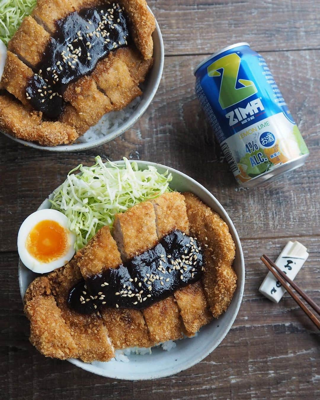 ZIMAのインスタグラム：「🍽新ZIMAと相性ピッタリ！Zimatchレシピ紹介🍽 ⁡  本日のレシピは【ずっしりカツ丼】😋 味噌だれをかけた熱々のカツ丼には、飲みごたえのあるレモン＆ライムがぴったり🎶 すっきりした味わいに酸味もほどよくあるので、揚げ物料理ともよく合います😉 ⁡ ＝＝＝＝＝＝＝＝＝＝＝  【ずっしりカツ丼】レシピ  ＝＝＝＝＝＝＝＝＝＝＝ ⁡ 【材料】2人前 ・豚ロース カツ用　2枚 ・塩、胡椒 　少々   ＜衣用＞  ・小麦粉  ・卵 ・パン粉 ⁡ ・サラダ油  適量 ⁡ ＜味噌ダレ＞ ・赤味噌　大さじ2 ・料理酒　大さじ3 ・みりん　大さじ2 ・砂糖　大さじ2 ・白だし　小さじ1 ⁡ ・ご飯　茶碗2杯分 ・キャベツ　適量 ・ゆで卵　1個 ・白ゴマ　少々 ⁡ ⁡ 【作り方】 ① キャベツは千切りにする。ゆで卵を作っておく。   ② 鍋に味噌だれの材料を入れ混ぜ合わせ、中火にかける。 こげやすいので、木べらなどで混ぜながら作業すると良い。とろみがついたら火からおろす。   ③ 豚ロース肉は筋切りをし、ラップを被せて麺棒などで軽く叩き、塩胡椒を振っておく。   ④ 小麦粉→溶き卵→パン粉の順に衣をつける。   ⑤ 170度ほどの油で④をキツネ色になるまで揚げる。   ⑥ 丼にご飯をよそい、千切りキャベツ、カットした豚カツ、ゆで卵を盛り付け、豚カツに②の味噌だれをかける。最後に白ゴマを振る。 ⁡ ＝＝＝＝＝＝＝＝  他のレシピも見てみたい！という方はZimatchサイトへGO‼💨  新しくなったZIMAとおうち料理の最高の出会いが見つかります✨  くわしくは公式サイトをCHECK👀 ⁡ #ZIMA #ジーマ #Zimatch #ジーマッチ #新ZIMA #新しい #リニューアル #酒 #お酒 #お酒好き #簡単レシピ #レシピ #クッキングラム #クッキング #instafood #foodporn #お酒好きな人と繋がりたい #フードペアリング #料理 #かつ丼 #カツ丼 #丼もの #かつ #味噌だれ #ベランピング #家キャンプ #おうちレストラン #おうちごはん #おうち時間 #おうち居酒屋」