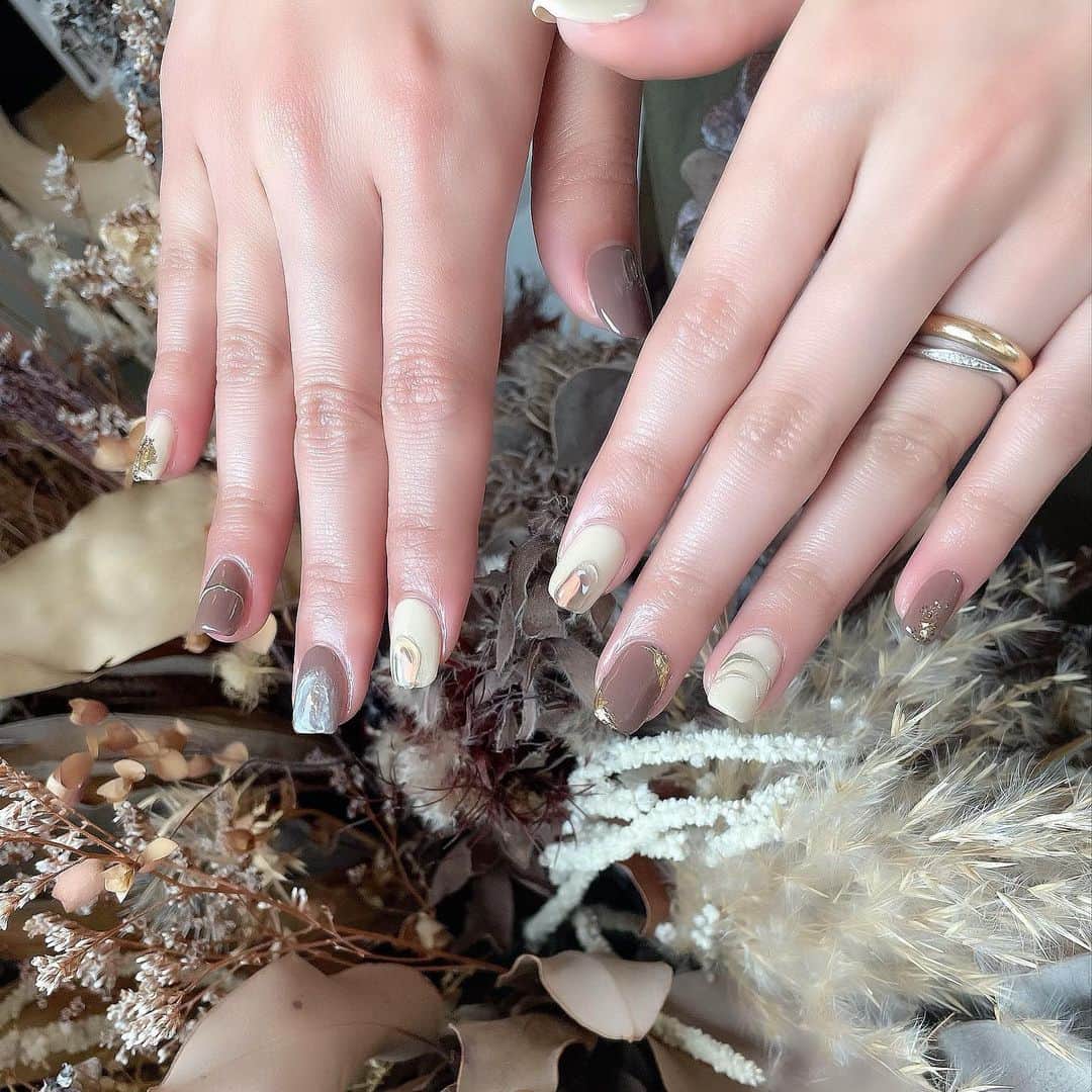 のインスタグラム：「New nail💅  秋色！かわいすぎ！ 秋の色はぜんぶかわいいよぉ〜 新色いっぱい入ってましたが くすみブラウンとくすみクリーム色で 作ってもらいましたぁ🌰🌝  私はいつも左薬指に ゴールドとシルバーの指輪を重ね付けしているのですが、 左薬指のネイルにもシルバー×ゴールドのにょろんを施してくれました😍✨ かわいすぎー。ネイリストさんのセンスが神すぎる。  ( @says_nail )  #akita #秋田 #nail #ニュアンスネイル #ブラウン #brown ##cream #2021autumn #秋ネイル #秋色  #gold #silver #saysnail #指輪とお揃いネイル」