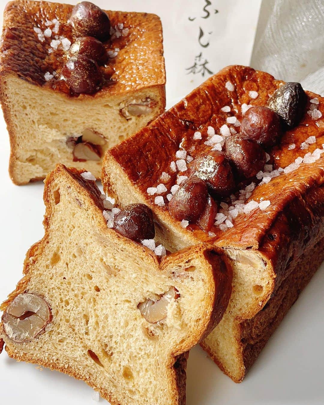 のインスタグラム：「プレミアムマロン〜✨🌰✨  食パンの最高峰 「ふじ森 」が 9/28まで伊勢丹新宿店 地下1階に出店中でございます〜 @fujimori_pain   初日に買いに行ったのですが、 栗をハーフ買ってしまい 足りなくて今日は一本買い😂  追いマロン〜 🌰  笑）    これはねぇ、パンと言うか  パンと焼き菓子の間のような存在で パン界の中でも わたしには このプレミアム感、ダントツの存在♡  トップの 金粉キラキラお栗さま、 中にもお栗さまゴロゴロ。 生でも焼いても冷やしてもおいしいです〜❤️🌰❤️  そして♡ 1番人気は「蜜芋 蜜りんご」食パン  熊野農園さんの、元祖種子島産 安納芋❗️ 蜜〜なリッチさと、りんごの爽やかさ 両方楽しめ、トップのアーモンドが香ばしさをプラス♡  どちらも ぜひに〜  。。。  ふじ森のパンはオンラインでも買えます。  で、オーナーの ももちゃんが はめてる指輪にショップのQRコードがついてて😆❤️  アイディア楽しいから 掲載しちゃお〜 （笑）最後のページね。😊  。。。  午後も楽しみましょうね 素敵な一日をお過ごしくださいませ〜💓  。。。  #ふじ森 #プレミアムマロン#食パン#伊勢丹新宿店 #デパ地下  #montblanc #モンブランの世界#モンブラン#栗#栗スイーツ#和栗#sweets#スイーツ#cake#里井真由美#入刀でございます #フードジャーナリスト里井真由美#断面モンブラン#蛋糕#断面フェチ#栗子蛋糕#さといいね #ありが糖運動#japan#japanese」