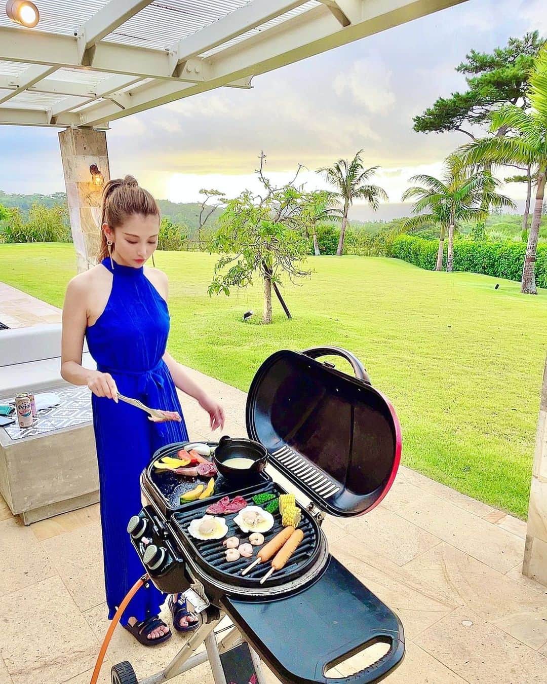 のインスタグラム：「. . BBQ～🍖 雰囲気だけで気分あがる🥳 . ビール普段は飲まないけど 沖縄来たらオリオンビール🍺 . パキッとした青が好き💙 庭用サンダルはスルーで🤭笑 . . #沖縄 #BBQ #オールインワン」