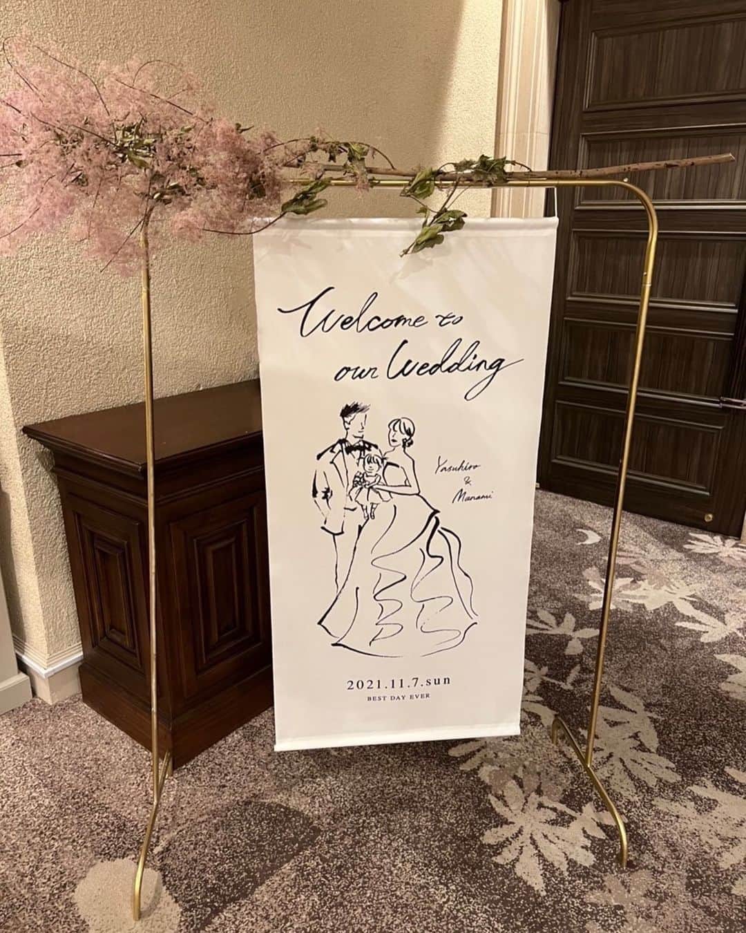 平木愛美のインスタグラム：「. copper stand / @artificialflower_macherieb  お花はアーティフィシャルフラワーでなくドライフラワーで。  #まなみんプレ花嫁   welcome bord ... tapestry   可愛すぎるタペストリー。💕💕💕 アートはオリジナルでオーダーして"夫と私"をイメージして頂き、ドレスなども完全再現して頂きました。  アントニオリーヴァのサイドの可愛いシルエットライン、ぱりっとふわっとしたボリューム感。 思い描く以上に素敵に描いていただきました。💭  ＆手に持っていたブーケの修正の流れから 娘も入った家族３人バージョンも描いて頂き、、  もう、ずーっと大切にしたい、アート。  式後も飾っておけるようにブラウンの、キャンパスのウェルカムボードも二人verで作成していただき。  プロフィールムービーでは、最初のシーンでは二人からの、動画のラストでは三人になっているという演出ができたり。 （最初のほうの部分がYouTubeにて先日アップされています🍋３人になるところの後編は後日、、、！）  プロフィールブックにも、使用させて頂いたりアートは大活躍でした。 一生大切な思い出としてこの絵をのこせるのでオーダーして良かったなと思います。💎  天才カメラマン福ちゃんのおかげで知った、chikakoさんのタペストリーやアートでした。💕👰🤵‍♂️ @fukudahitomi610   art - tapestry / @chikako_mk」
