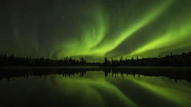 Explore Canadaのインスタグラム：「This is a performance you don’t want to miss! At times elusive, the northern lights are a natural phenomenon so striking, people travel from across the globe for a chance to catch a glimpse.  Did you know there’s a whole science behind this stunning show? 🔭 The northern lights happen in the Northern Hemisphere when the sun’s electrically charged particles, riding on a solar wind, enter the Earth’s atmosphere and collide with gases. Each gas produces a different colour. Oxygen is the most common gas in Earth’s atmosphere, which produces a green colour, while nitrogen produces the rarer red hue.  It’s possible to see the lights almost anywhere in Canada during all four seasons. But northern regions are the best place to see them, and the place where they are the most active. Winter (December to March) is often the luckiest season, thanks to more hours of darkness each day and frequent cold, clear nights. The best time? Around midnight — 10pm - 2am is the window, so get ready to stay up late. But we promise, this show is worth it ✨  For more on experiencing the northern lights and all that winter in Canada has to offer, visit the link in our bio.   *Know before you go! Check the most up-to-date travel restrictions and border closures before planning your trip.*⁠⁠  📷: @bigredtimelapse  📍: @travelyukon   #ExploreYukon #ExploreCanada   [Video ID: A timelapse of the northern lights dancing across a dark night sky. Green ribbons move across the sky in all directions and reflect off the dark water below.]」