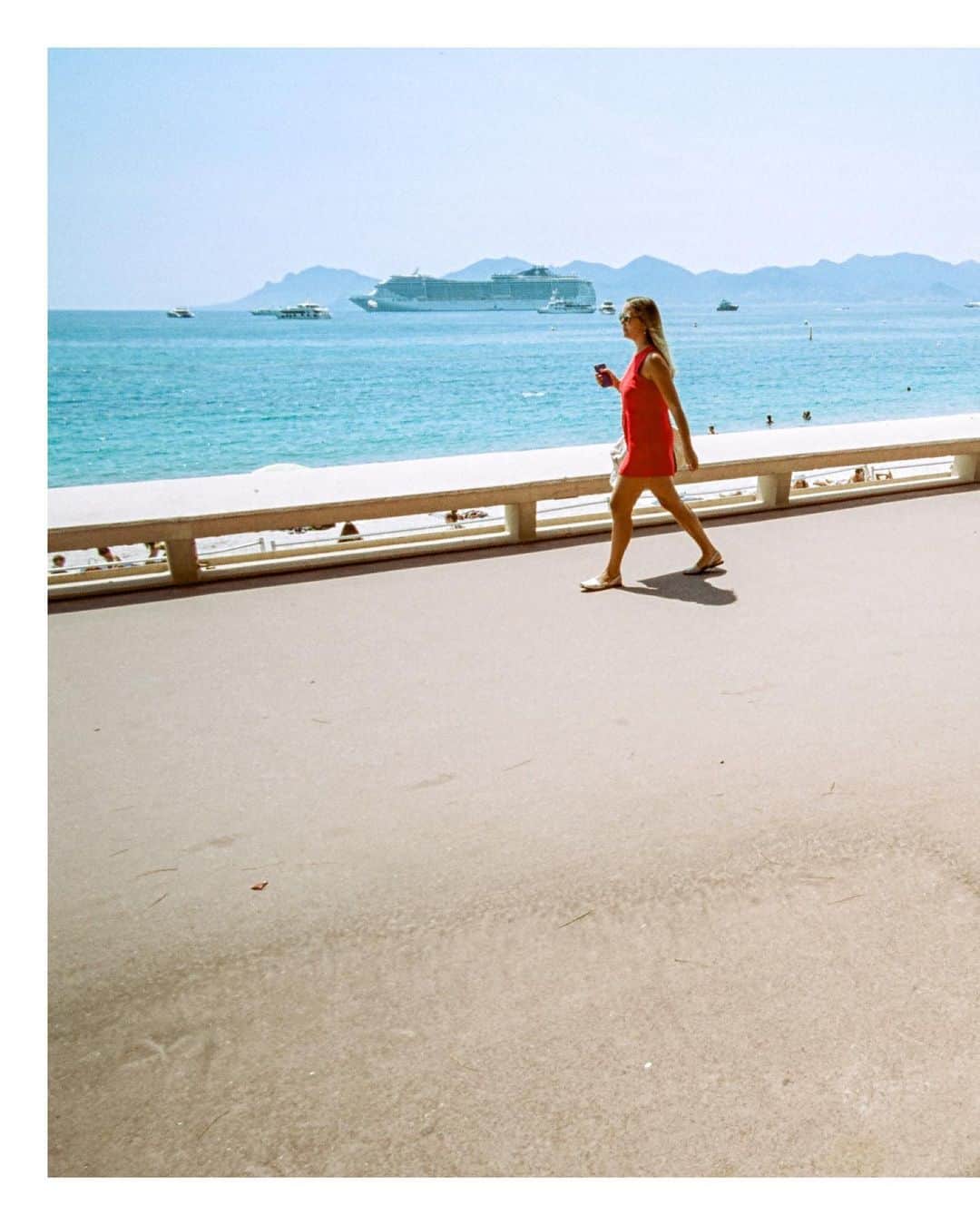 Pete Halvorsenさんのインスタグラム写真 - (Pete HalvorsenInstagram)「The 3rd image from my Cannes series is now minted and live on @superrare.co   With this image we are back on the world famous Promenade de la Croisette. A short story on this image, and what I look for when shooting on the street:  The scene - I noticed this elderly gentleman sitting reading his paper facing the sea...a young man next to him earphones on lost within his phone. Struck by the juxtaposition of the two generations consuming their information differently on the same bench, I composed my frame.  A Lady In Red approached, both generations of "watchers" decided to look up simultaneously and watch her stroll by. This is where the compose and wait technique pays off...  The pieces of the puzzle are all laid out, it's my job as the storyteller to put them together for the viewer, so without a caption - can the story can still be told?  Can the frame speak for itself?   Colour for me is a big part of that story.  Shooting on film, while more difficult to "quickly review" images creates creative guardrails that allow for the photographer to work within. @cinestillfilm 50D is one of those that compliment my love of bright blues/deep reds...it pairs nicely with a day walking around Cannes.  This is where compose and wait comes in, I had his red pants on one side, just needed something to connect it to. The woman in the dress approached...gave me colour connection for the viewers eye to go back and forth between the two sides of the frame.  Colour...composition...patience, and a bit of luck. Proud to add the 3rd image from a summers day in Cannes...through the eye of my @leica_camera M7 rangefinder, the light frozen in time on CineStill Film and now minted on the blockchain and available as a 1/1 on @superrare.co」2月13日 2時34分 - petehalvorsen