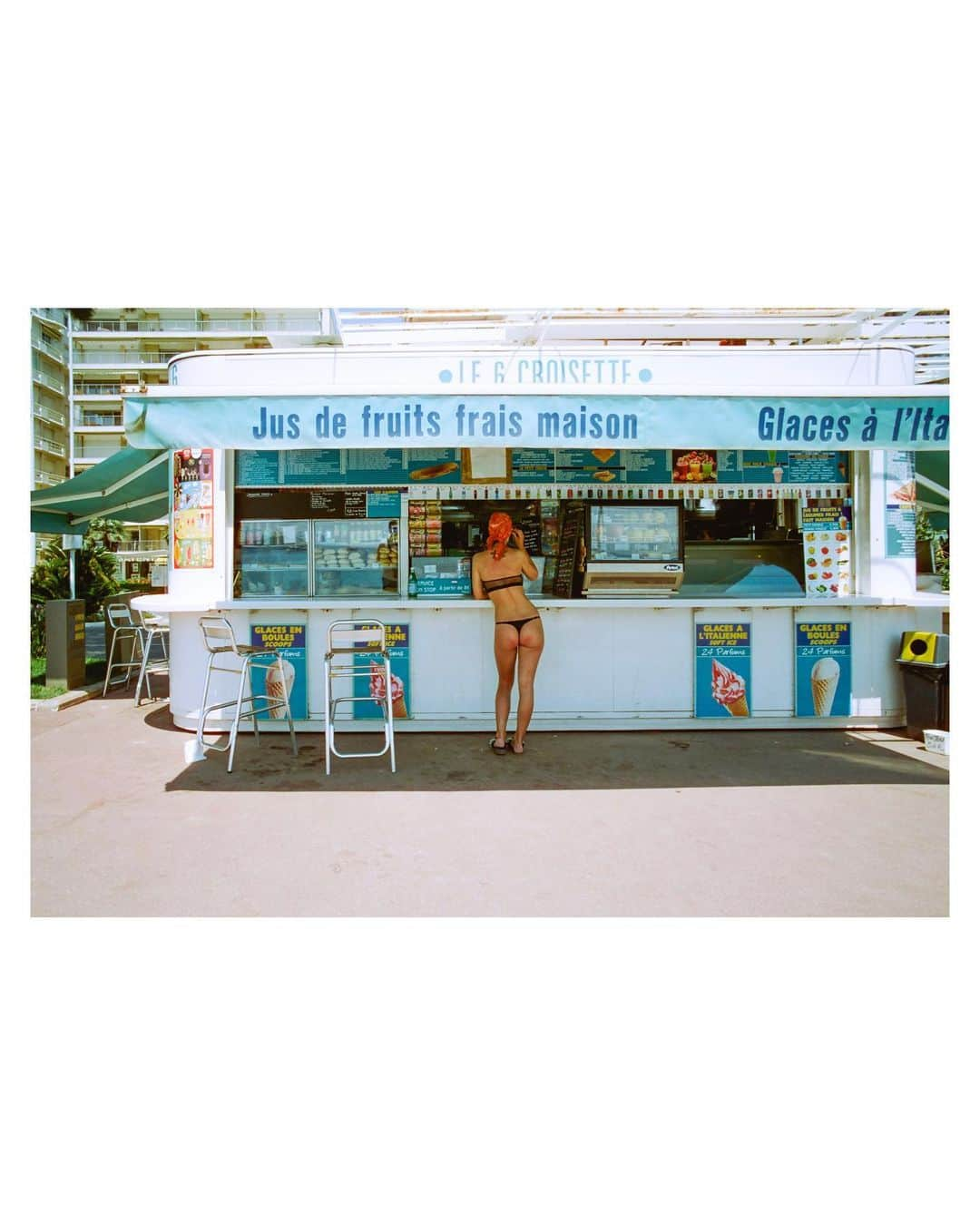 Pete Halvorsenのインスタグラム：「While spending time in Cannes I'm always struck by the feeling of going back in time to the 1960s. Wanting to share that vintage feel with the images I capture while there, I usually shoot on film.   When walking along La Croisette i have the sounds of Peter Sarstedt's "Where Do You Go To My Lovely" and envision Slim Aarons riding his bike with cameras around his neck. On this hot June afternoon, a sun worshiper took a break from the rays to cool off with an ice cream cone and a cold drink. The scene set itself in front of me. A single moment captured on my Leica, the light frozen in time on CineStill Film...and now minted on the blockchain.   Now available as a 1/1 on @superrare.co」