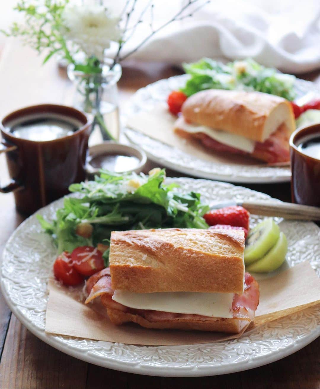まいちくのインスタグラム：「2022.1.30🥖 ． ． 今日の朝ごパンプレート ． ベーコンチーズサンド グリーンサラダ🥗 フルーツ🍓🥝 コーヒー☕️ ． ． ゆっくり起きて ゆっくりごはんの支度して 時間に追われない朝って幸せ♡ ． ． テーブルのお花は @bloomee さんから届いた今週のブーケ ． ガーベラ ソリダコ 日向水木 ． ． プチサイズのブーケはテーブルの上で楽しめて嬉しい✨ ． ． 昨日、地場野菜を買いに行ったらミモザがもう売ってて早速お迎えしました♡ 外はまだ極寒だけどおうちの中は小さな春♪ 早く暖かくならないかな。 ． ． 今日もおうち時間、楽しんでいこー！ ٩(ˊᗜˋ*)و ． ．  #foodstagram #instafood #delistagrammer  #おうちごはん#フーディテーブル #igersjp#ellegourmet #おうちごはんLover #マカロニメイト#ご飯でエールを #homecooking #foodlovers#foodie #ブルーミー#bloomee#花の定期便 #花のサブスク#PR」