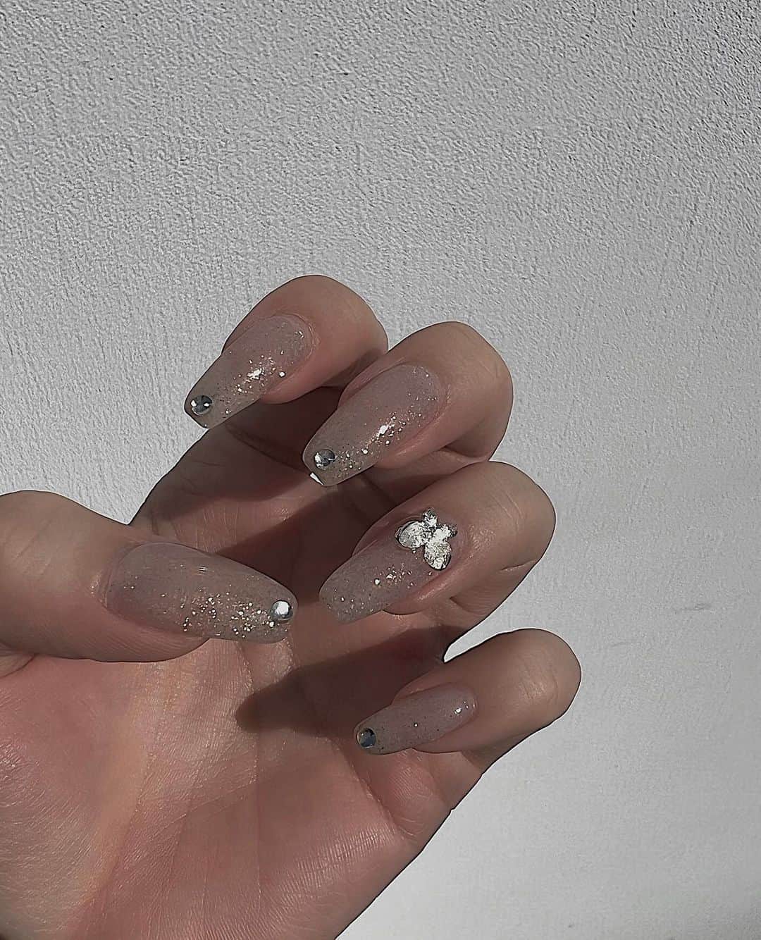 小原優花のインスタグラム：「Nail🦋 @ellenail_shibuya   少しパープルが混ざった感じのクリアベージュのラメ🥰 色味に一目惚れしました💘  パーツはミニ蝶々とビジューどっちか迷って片手ずつどっちも付けて頂きました☺️👐🏼笑  透明感のあるキラキラネイル可愛すぎてお気に入りです🪄💎💖  elle nailさんありがとうございました💗😍 ▽渋谷店 @ellenail_shibuya   ▽新宿店 @ellenail_shinjuku   #nail #nailsalon #ネイル #ネイルサロン #ellenail #エルネイル #ネイルデザイン #ジェルネイル」